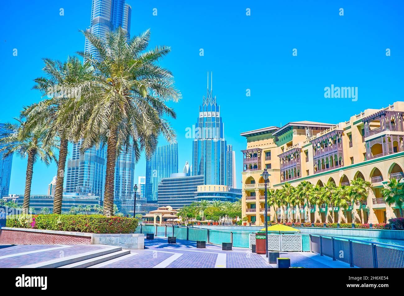 The pleasant walk along the bank of Burj Khalifa Lake and enjoy great traditional Arabic architecture of Old Town Island complex with palm trees and h Stock Photo
