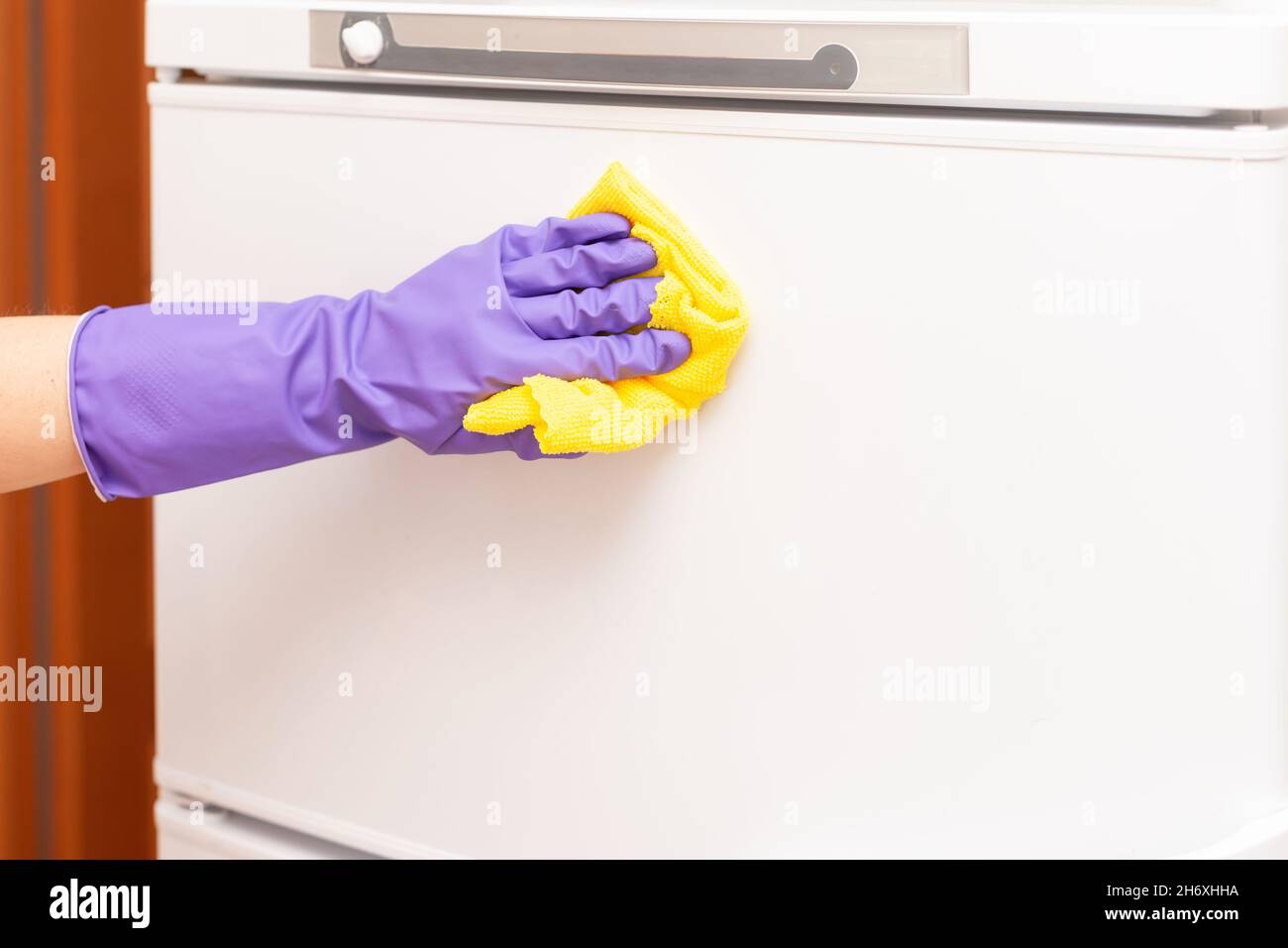 woman's hand wipes the white refrigerator door Stock Photo