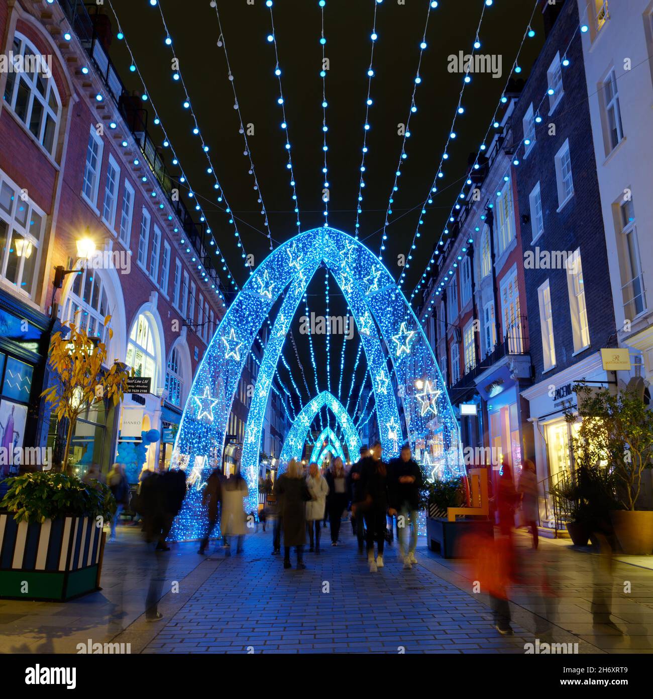 Christmas lights at night on South Molton Street as pedestrians walk by blurred by the long exposure Stock Photo