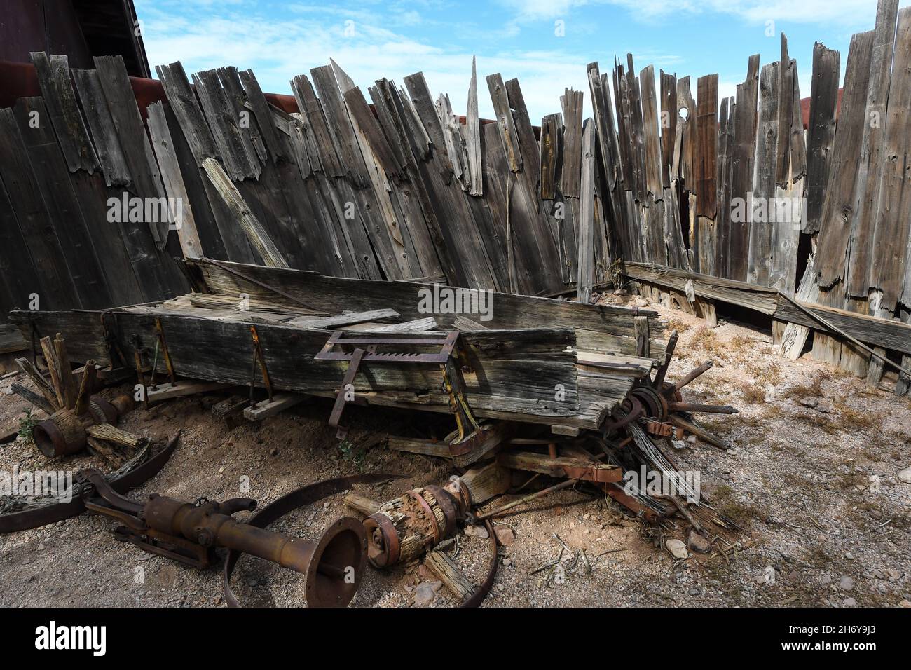 Old west decaying wagon with broken down wood fence in the background Stock Photo