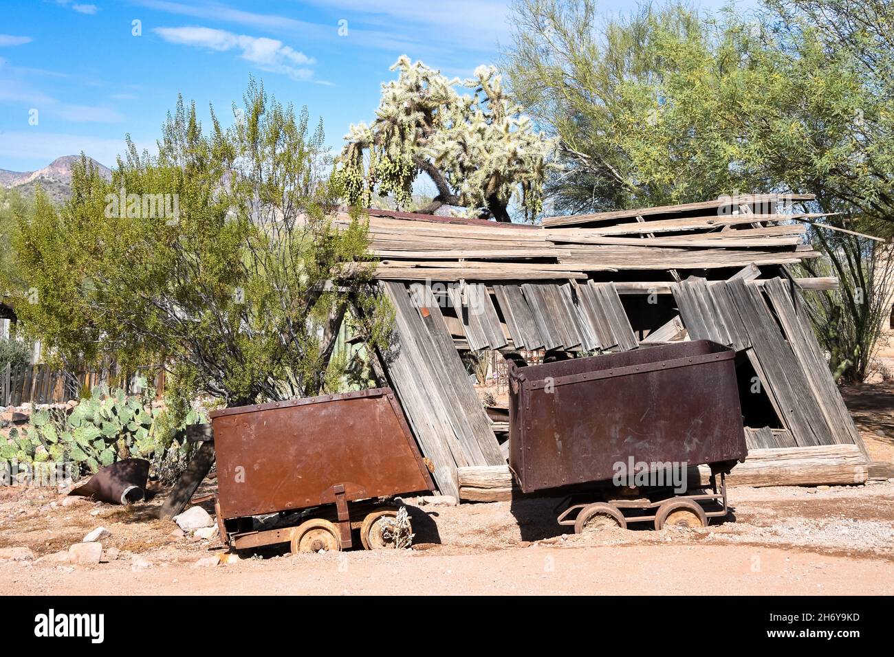Mining carts with collapsed building in background Stock Photo