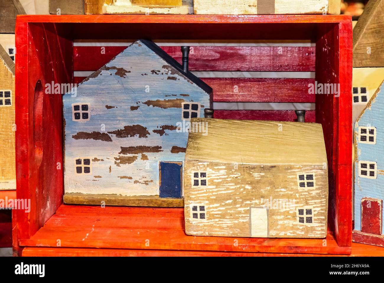 Rustic homemade wooden block houses sitting in and around a red wooden