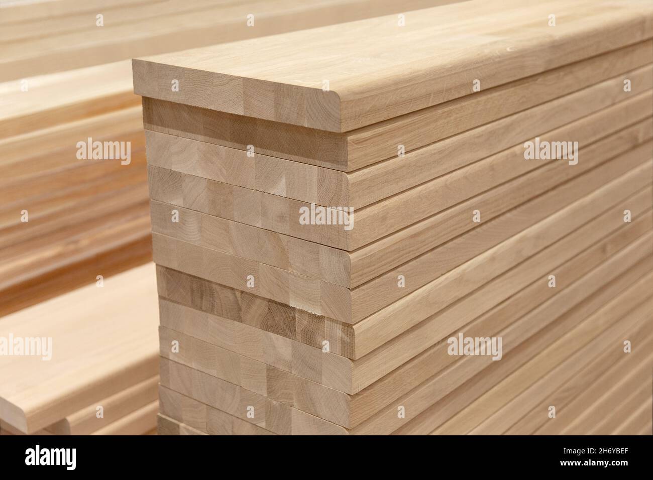 Row of Edge Gluing Boards, Stacks of strong wood planks in a store or on a building site. Natural rough wooden boards boards, lumber, industrial wood Stock Photo