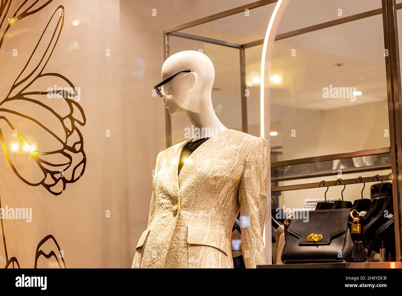 Fashionable women mannequins in trendy casual clothes on the clothing retail store window in the shopping mall. Stock Photo