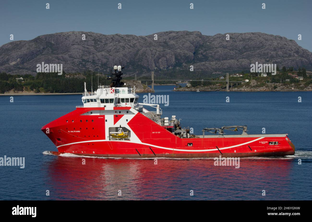 KL Saltfjord, anchor handling tug supply vessel for 'K' line.  Sailing from Bergen, Norway.  Norwegian coastline and mountains in background. Stock Photo