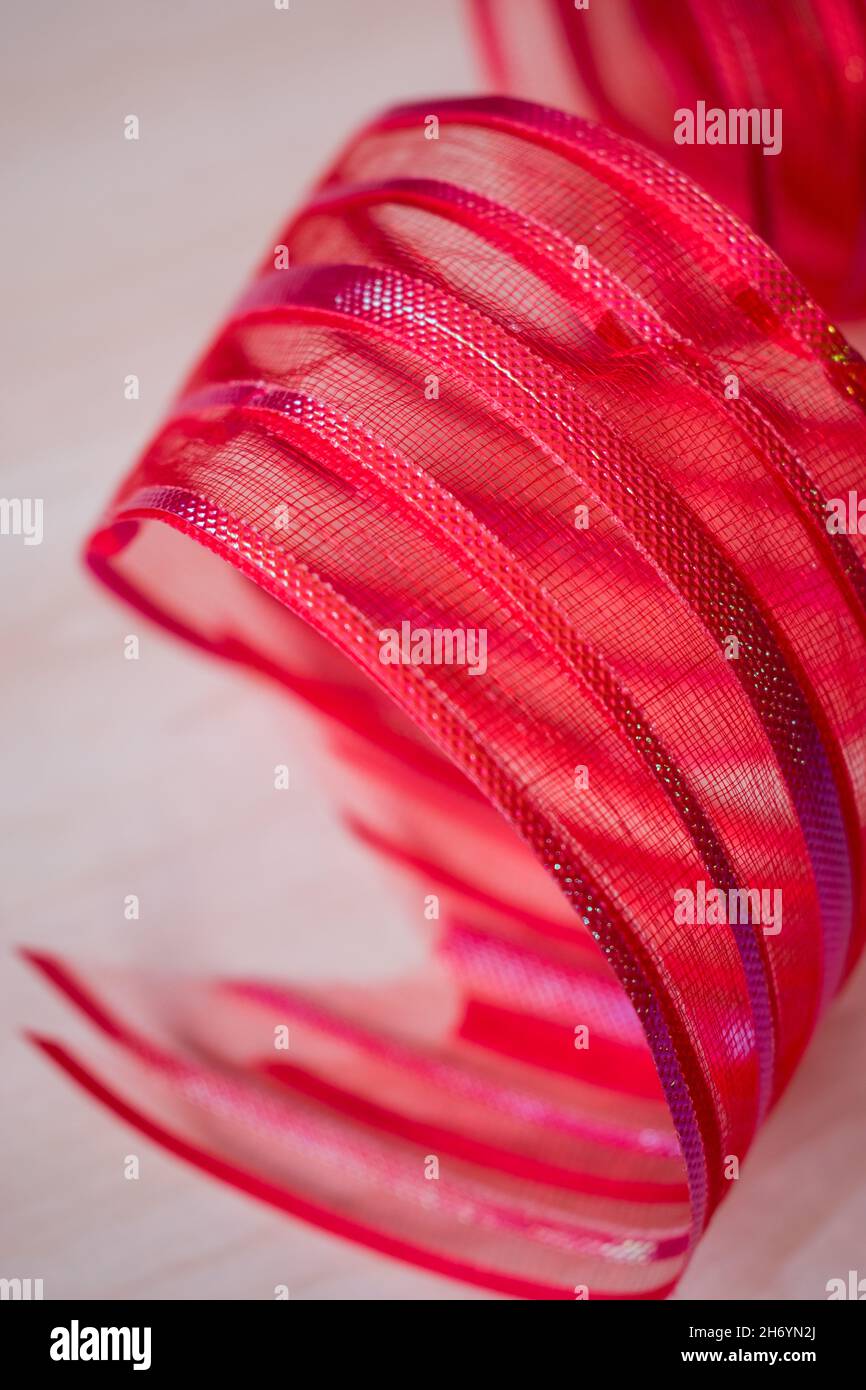 Close up of a red bow ribbon on a white surface Stock Photo