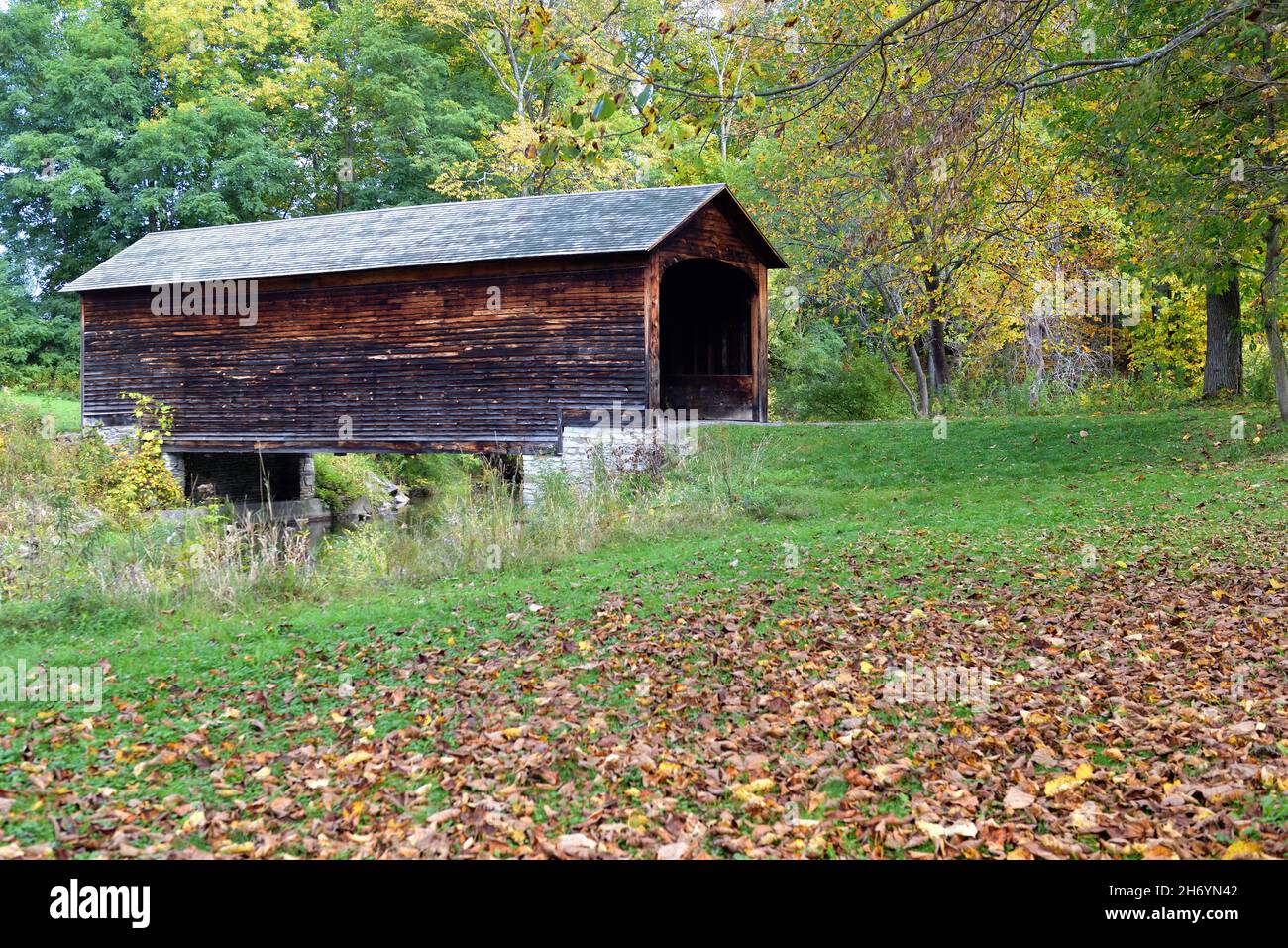Cooperstown, New York, USA. An early autumn view of the Hyde Hall Covered Bridge over Shadow Brook. The bridge was built in 1825. Stock Photo