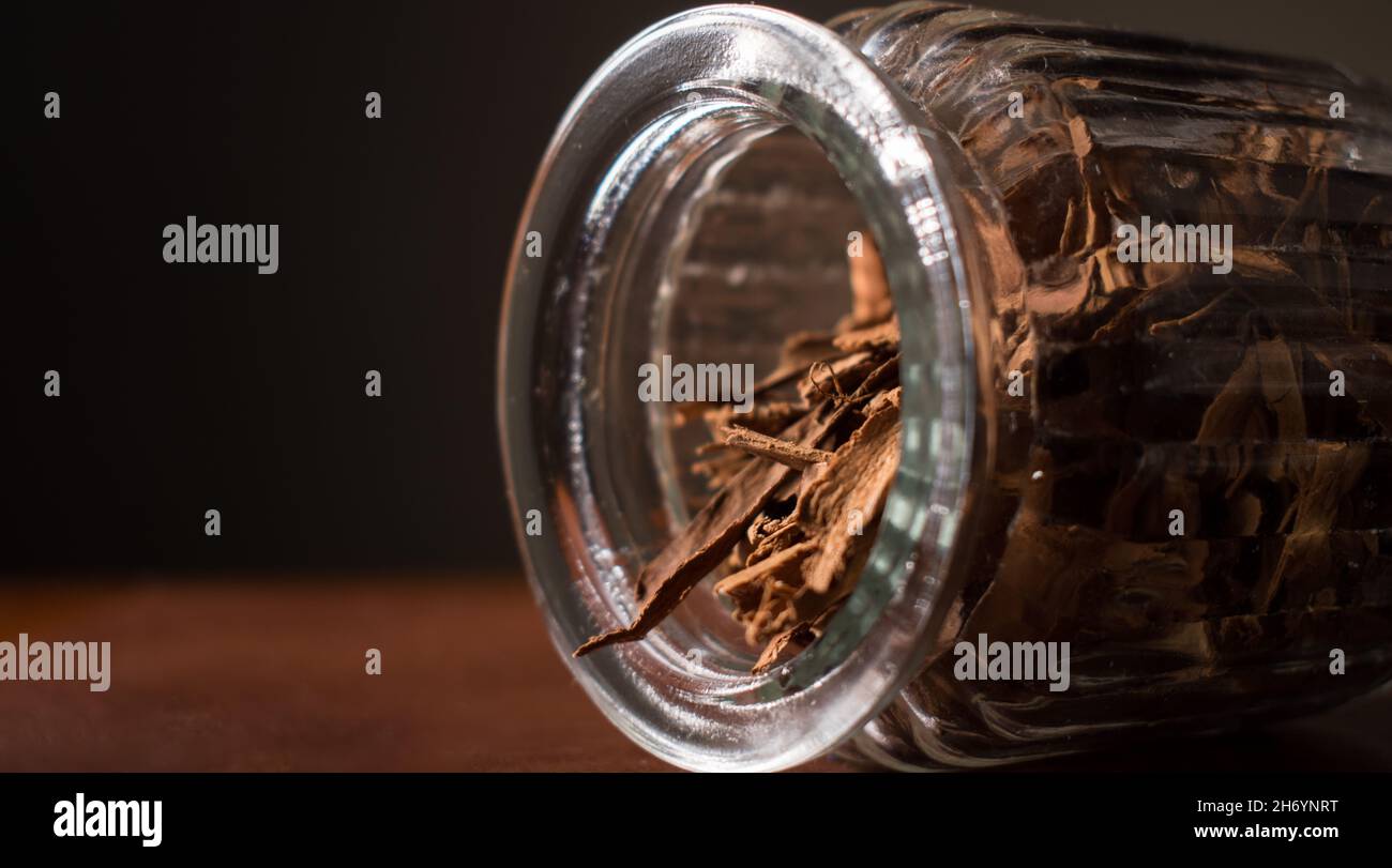 Cinnamon sticks in a glass pot on a brown table Stock Photo