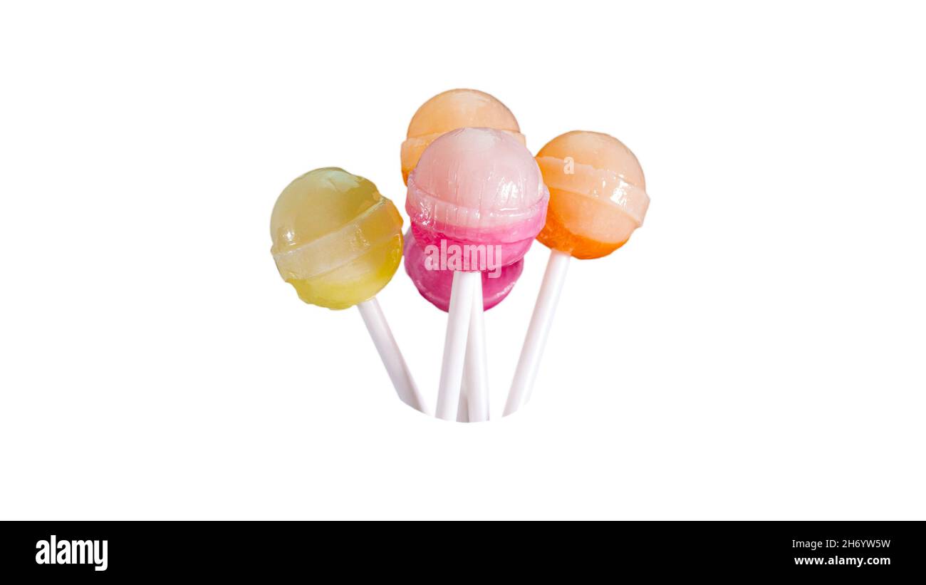 Many fruit lollipops of different colors, candy on a stick isolated on a white background. Stock Photo