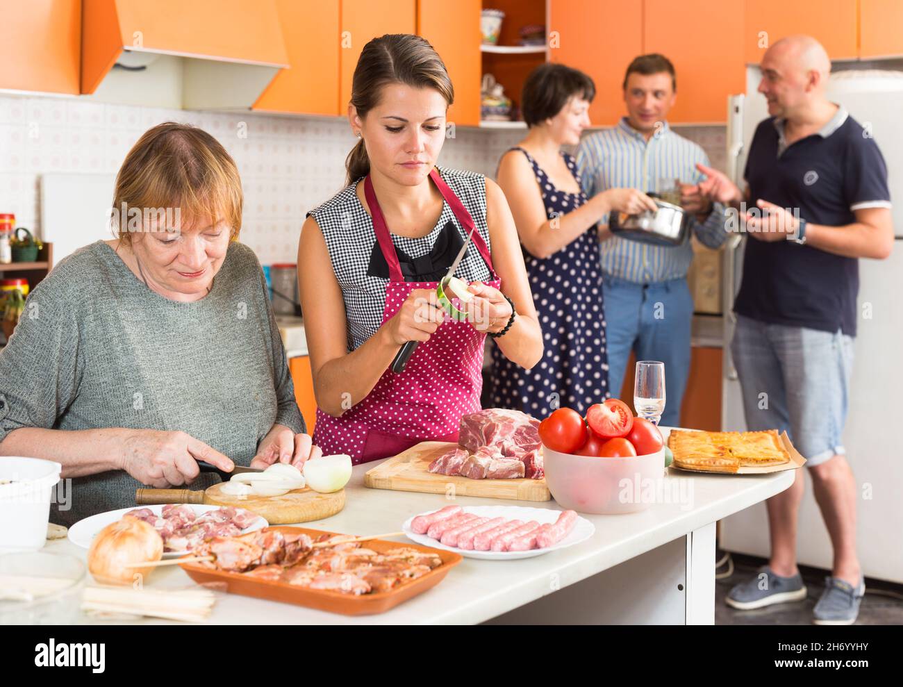 Senior woman and her daughter-in-law preparing dinner Stock Photo