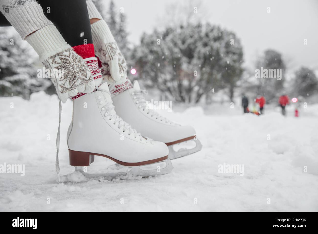 Ice skating woman getting ready lacing leather skates boots to go skate
