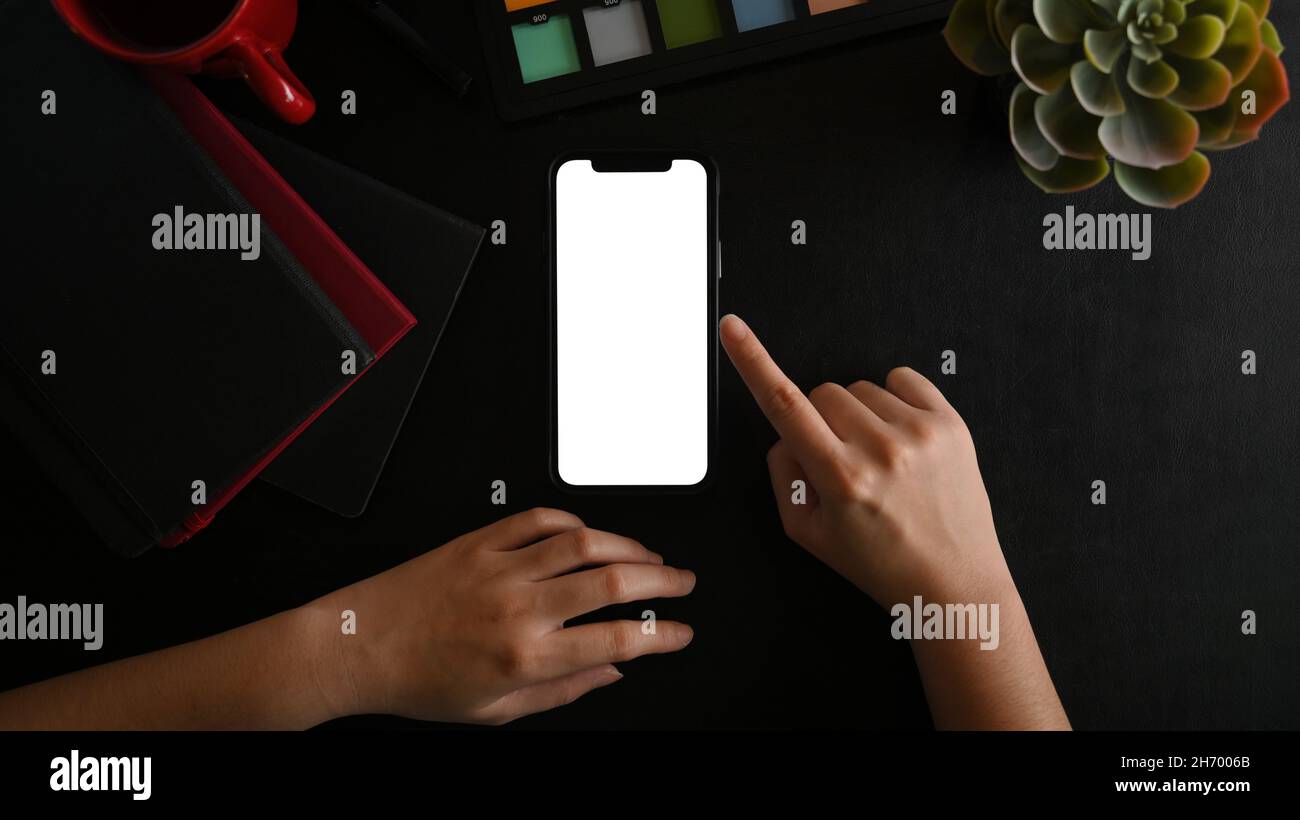 Close-up female hands using smartphone blank screen mockup on black ...