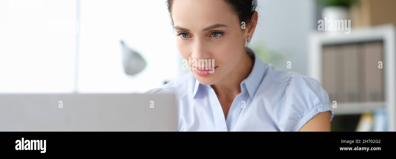 Young serious focusing business woman working at laptop Stock Photo