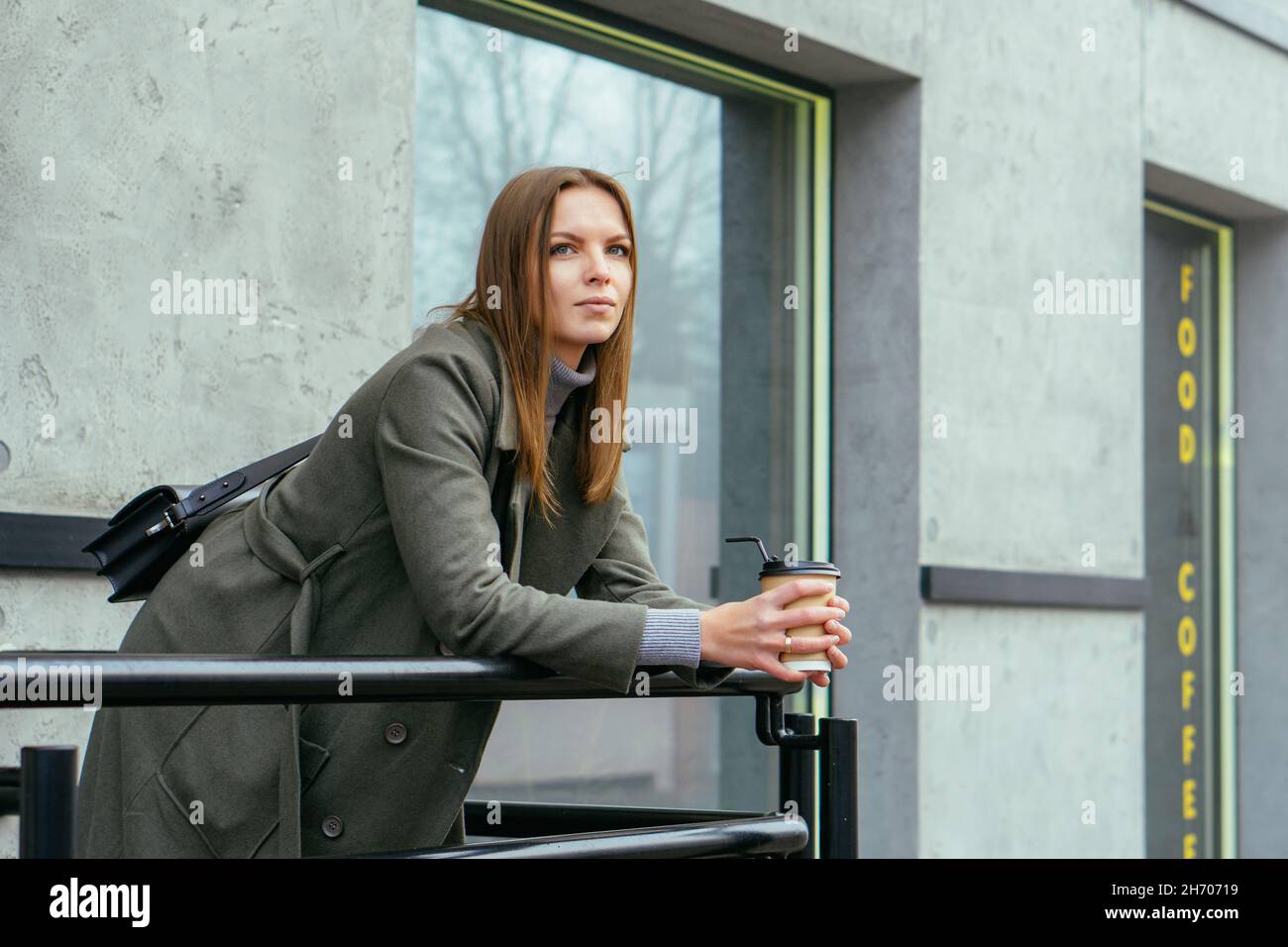 Outdoors lifestyle portrait of stunning girl. Drinking coffee on the city street Stock Photo