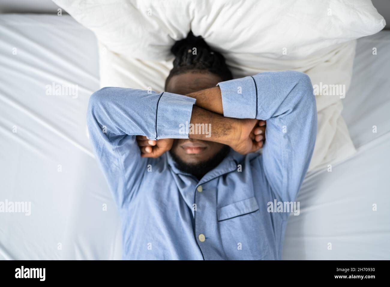 Young Man Suffering From Insomnia Lying In His Bed Stock Photo