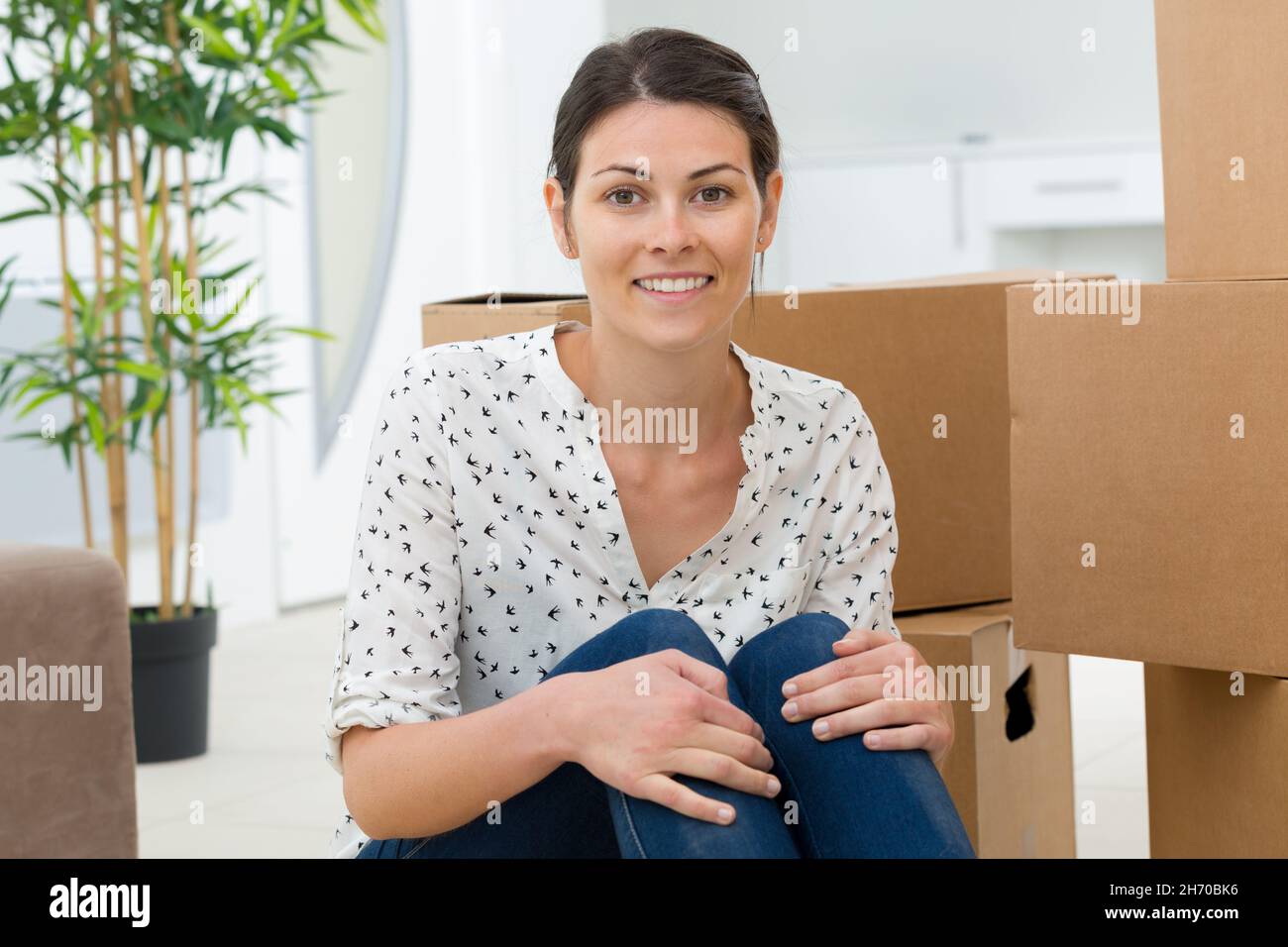 portrait of woman sat amongst cardboard boxes Stock Photo - Alamy