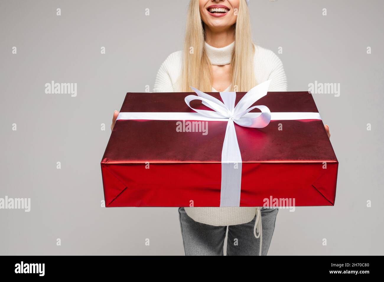 Smiling young lady holding present in studio Stock Photo