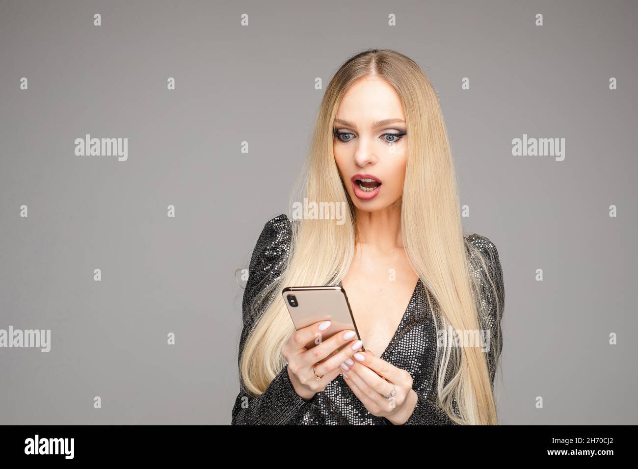 Pretty lady in black dress looking on gadget screen Stock Photo