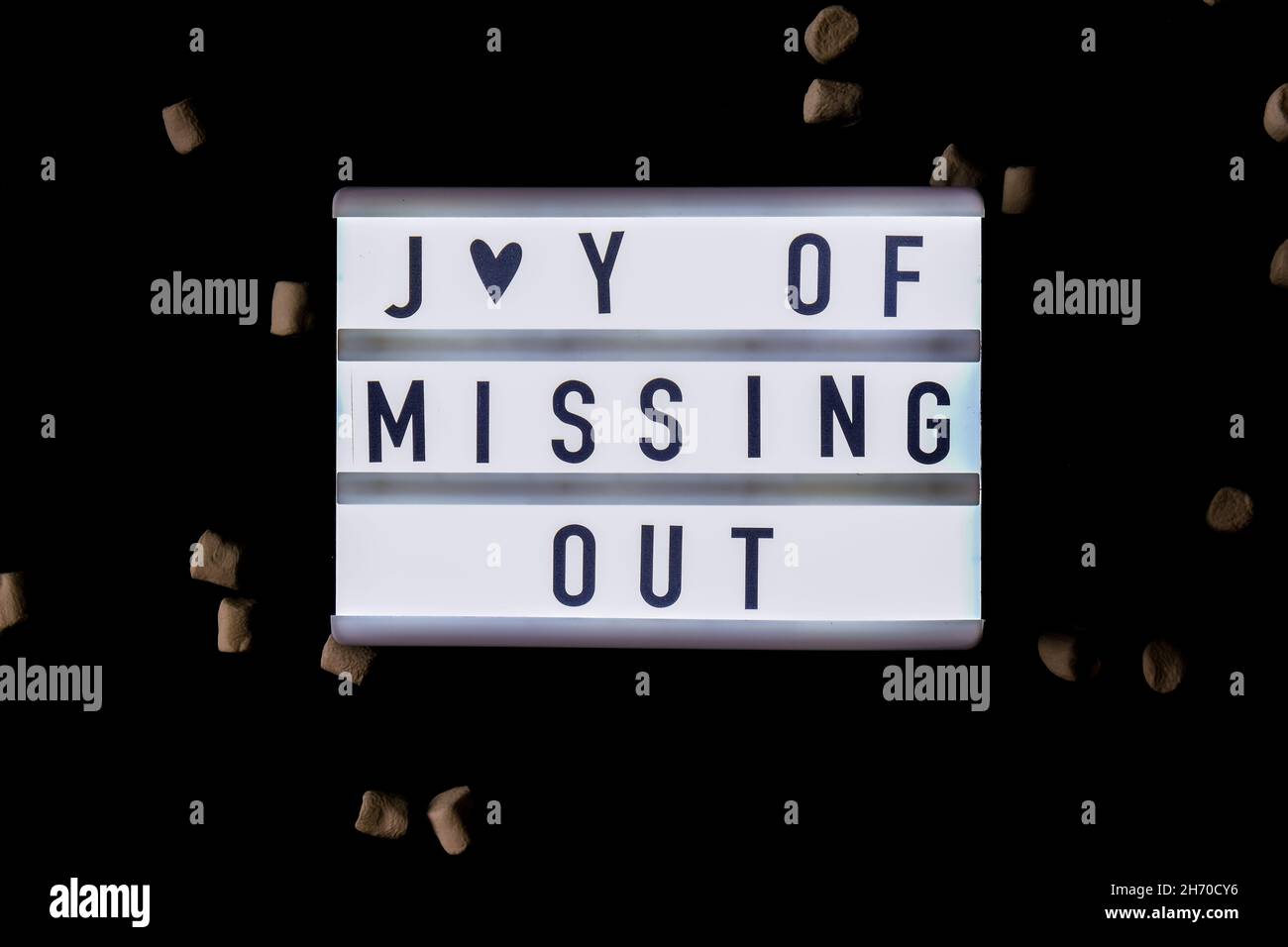 Lightbox with text JOMO Joy of Missing Out. The concept of relaxation from information and gadgets. Top view. Flat lay. Stock Photo