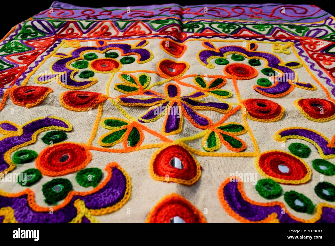 Beautiful embroidery multicoloured hand crafted thread work with mirrorwork from Kutch district bhuj called Kutchi embroidery. Embroidery work backdro Stock Photo