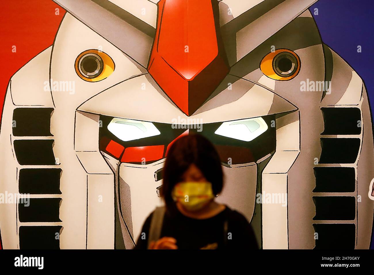 Taipei, Taipei, Taiwan. 19th Nov, 2021. A lady wearing a face mask is seen  in front of banner with a giant Gundam head of model RX-78-2, at an  exhibition of classic Gundams'