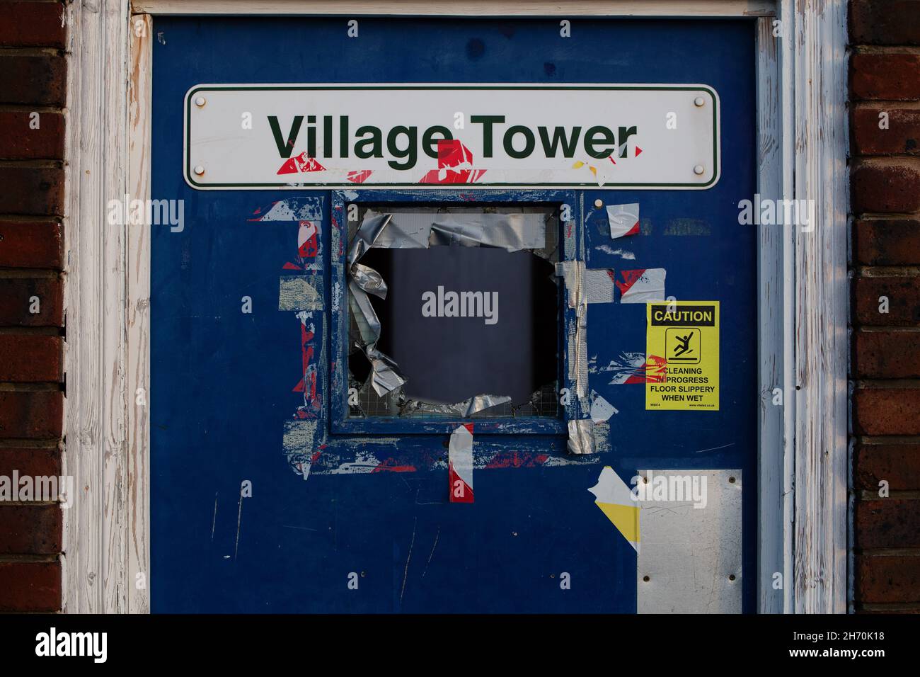 A smashed window on the door of Village Tower multi-storey carpark in Beckenham, London, United Kingdom Stock Photo