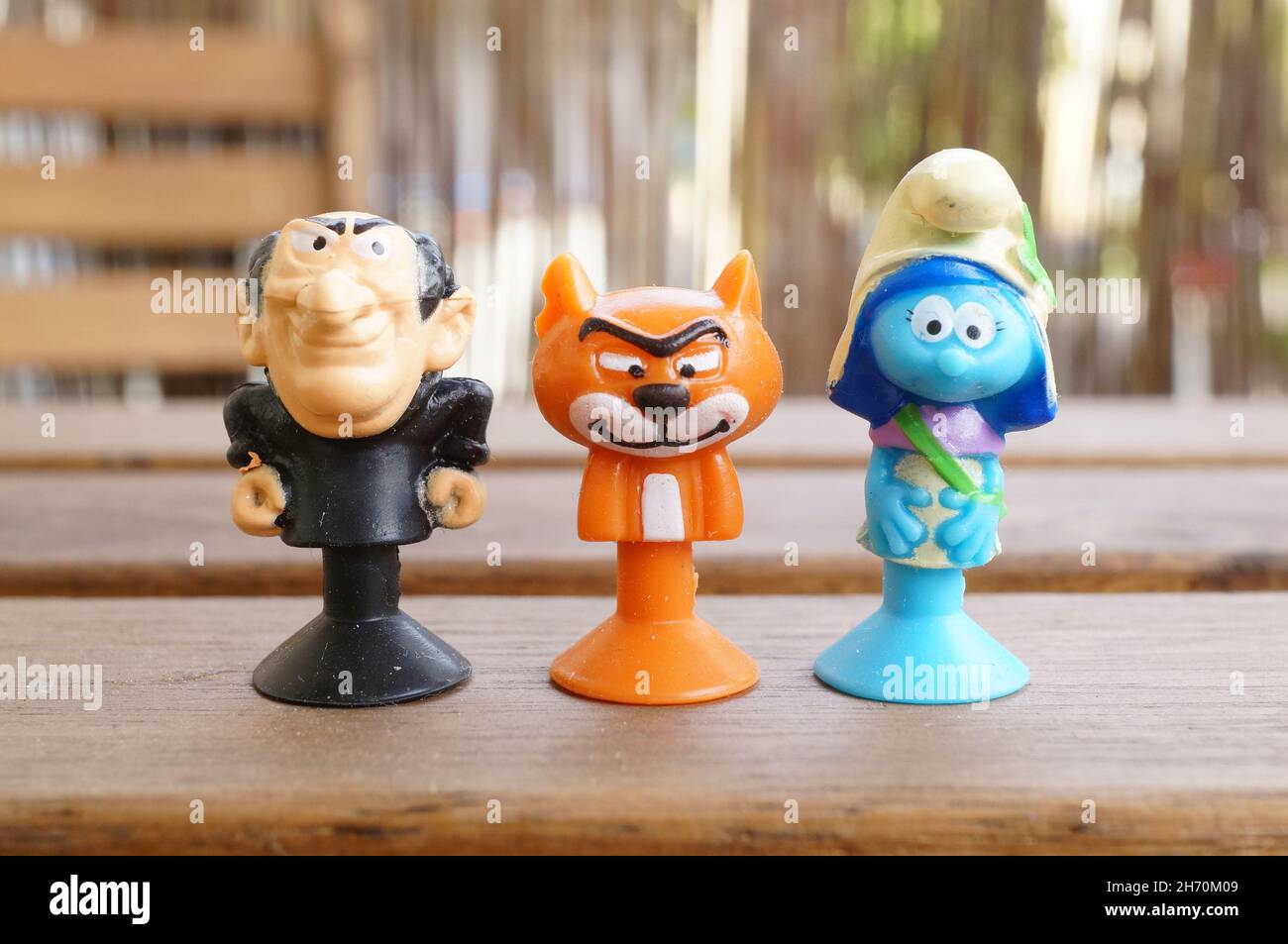 POZNAN, POLAND - May 14, 2017: A closeup shot of Gargamel, Asrael, and female Smurf toy figurines on a wooden table Stock Photo