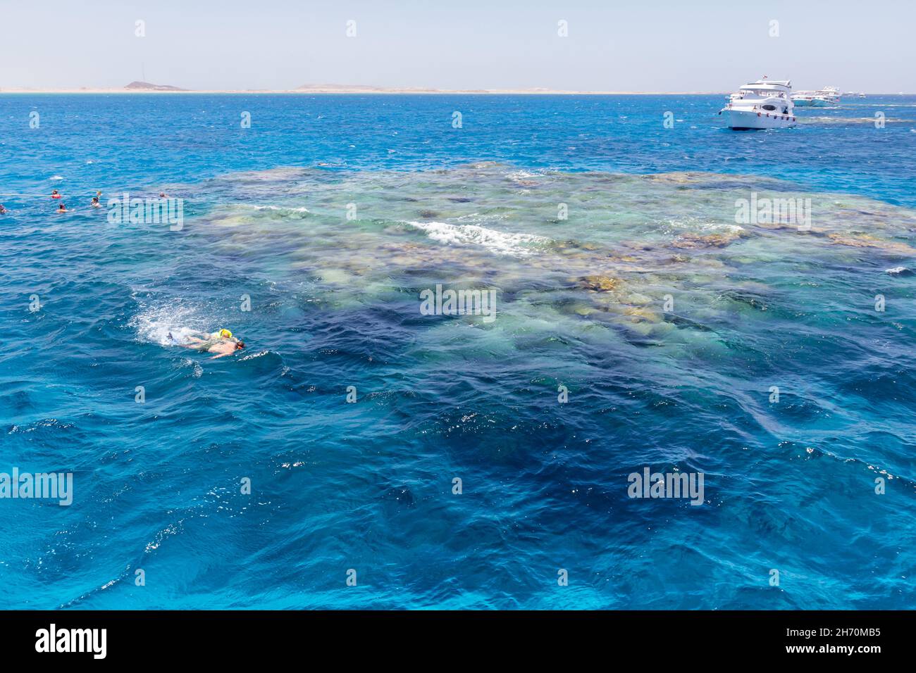 SHARM EL SHEIKH, EGYPT - JUNE 7, 2021: Luxury yachts with tourists in a bay of the Red Sea in Sharm El Sheikh in Egypt. Some tourists are snorkeling t Stock Photo