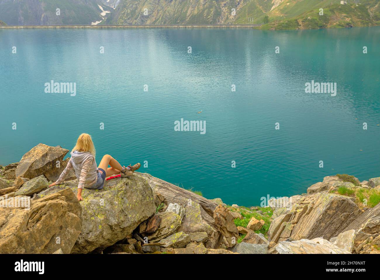 Swiss reservoir in Maggia Valley of Ticino canton. Top of aerial tramway station from San Carlo town of Switzerland. Tourist woman in trekking dress Stock Photo