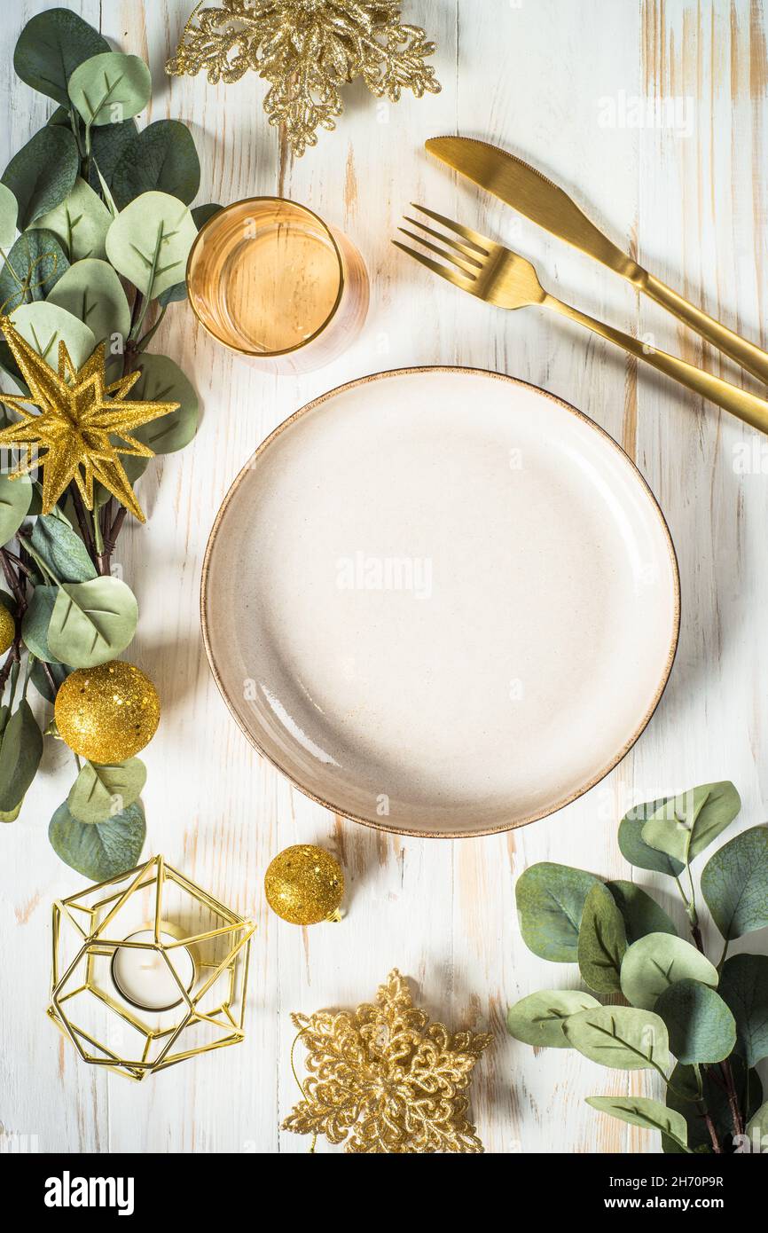 Christmas table setting with eucalyptus leaves and golden decorations
