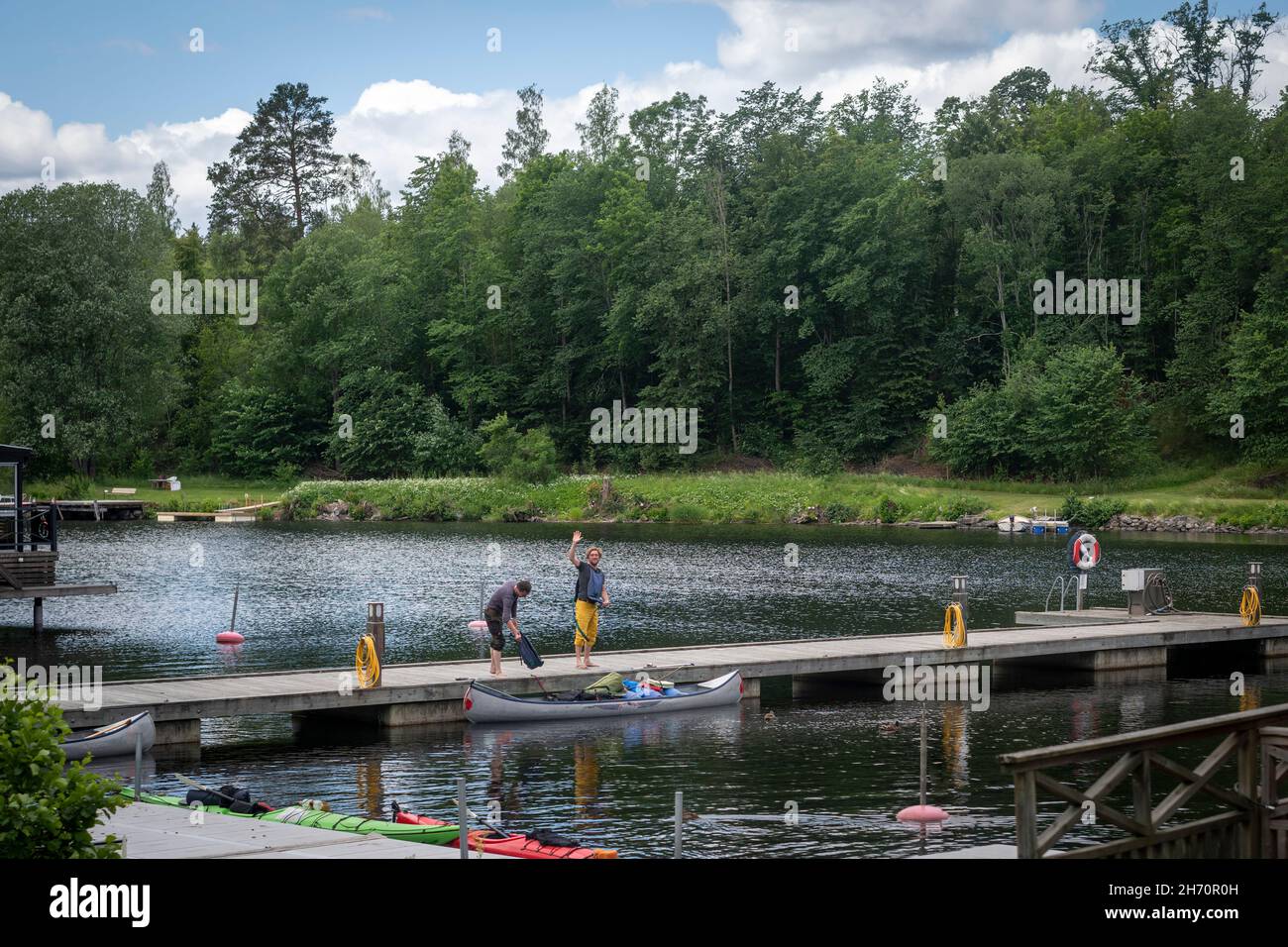 Men on jetty at river Stock Photo Alamy