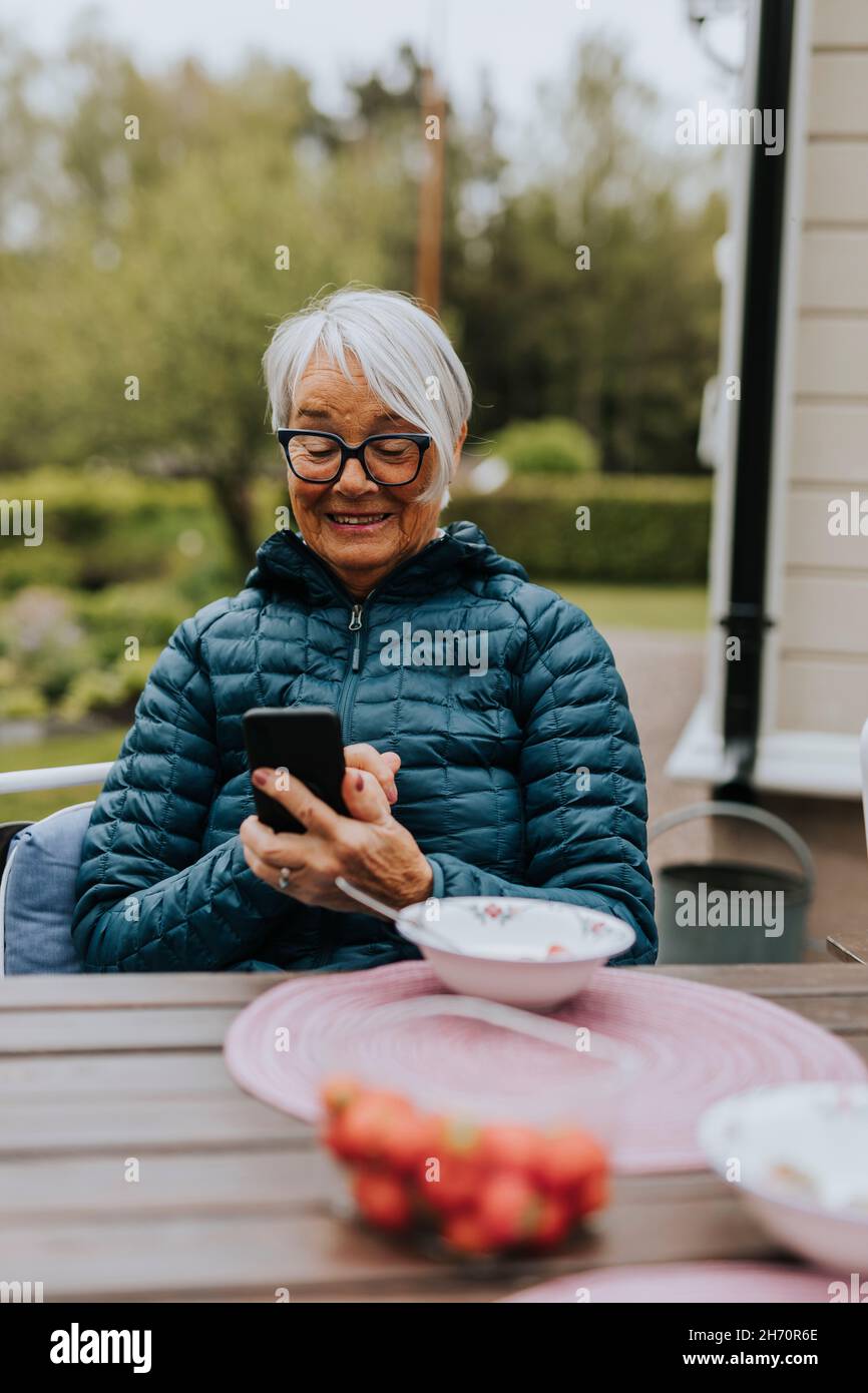 Smiling woman using phone Stock Photo