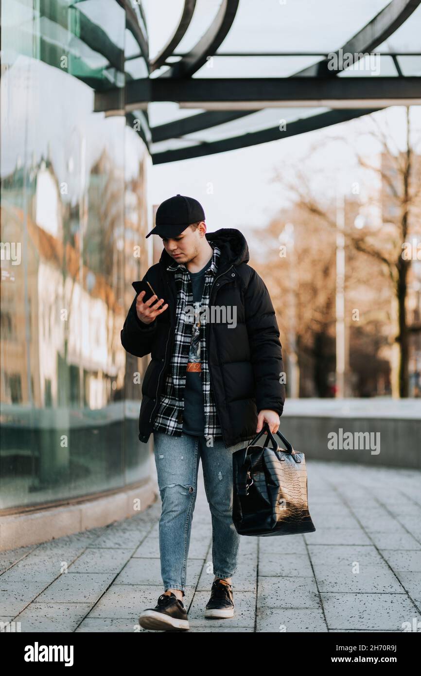 Man looking at his phone while walking Stock Photo