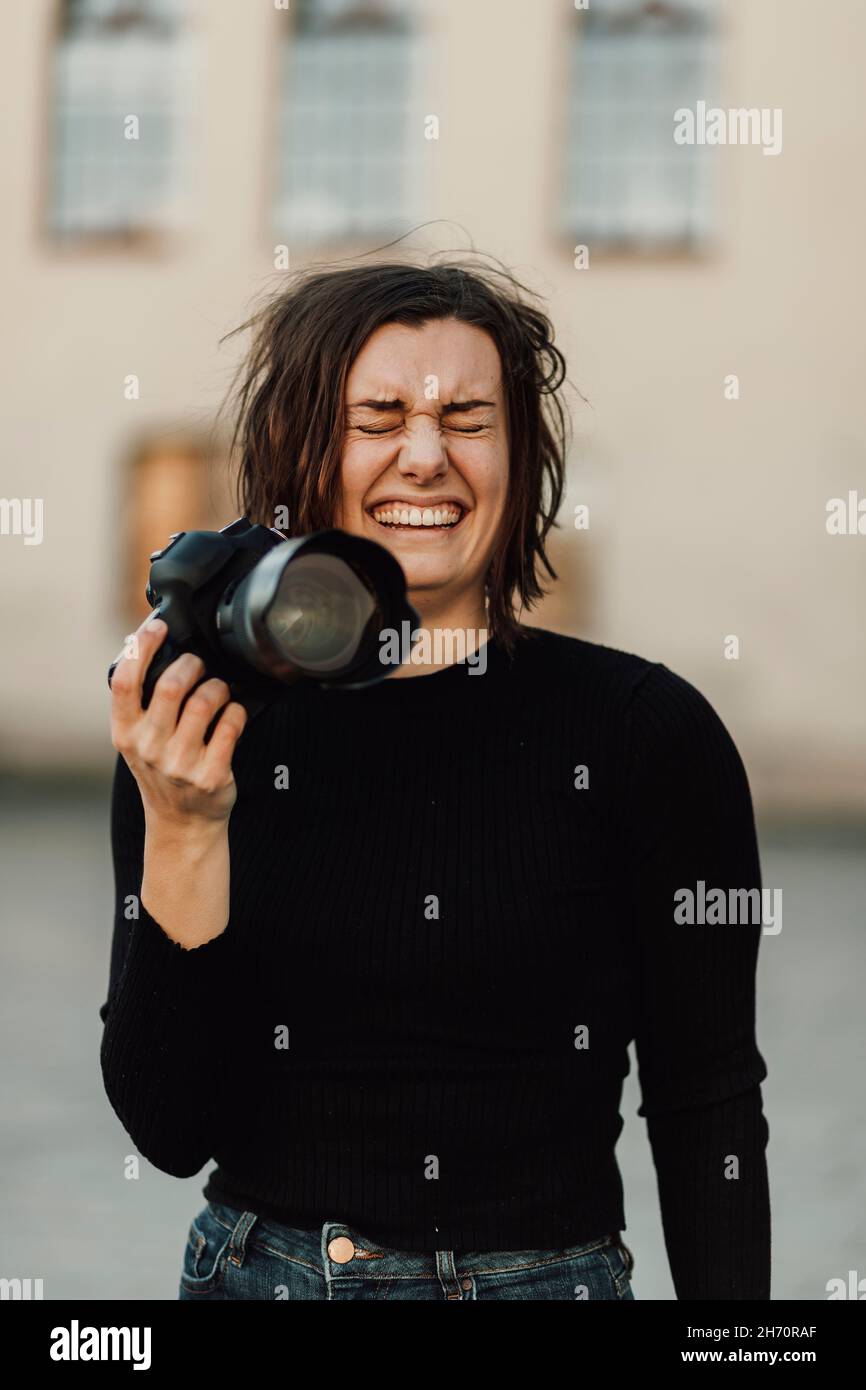 Happy woman holding camera Stock Photo