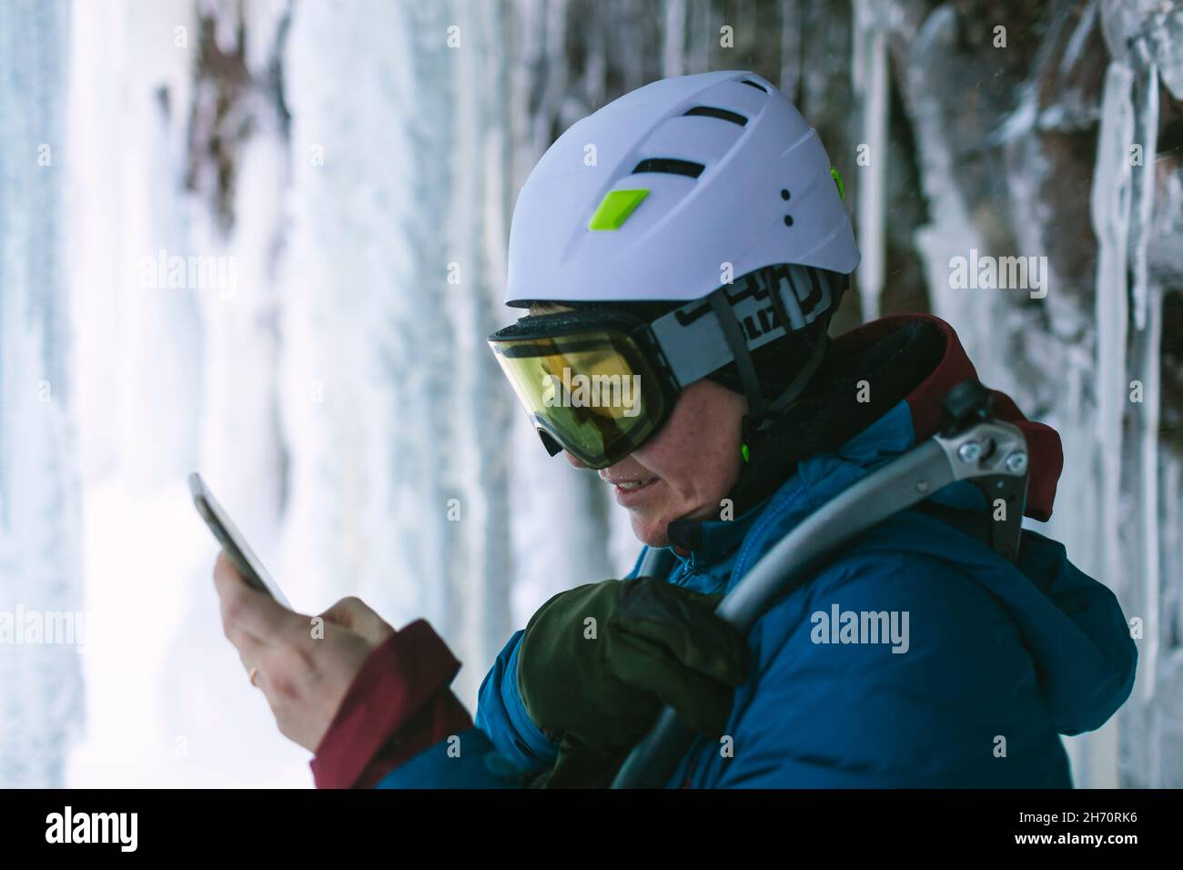 Female ice climber using cell phone Stock Photo