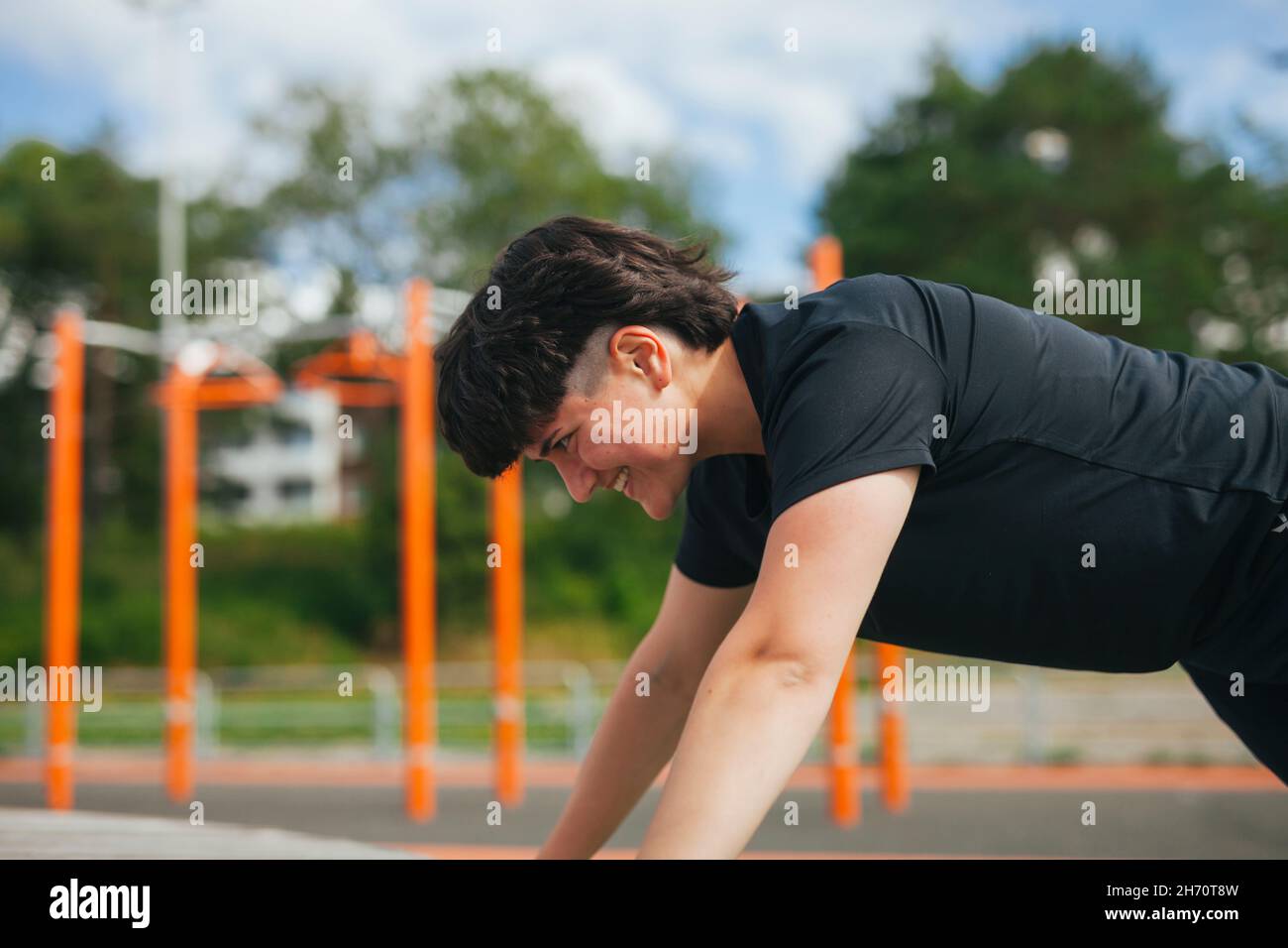 Young woman exercising at outdoor gym Stock Photo