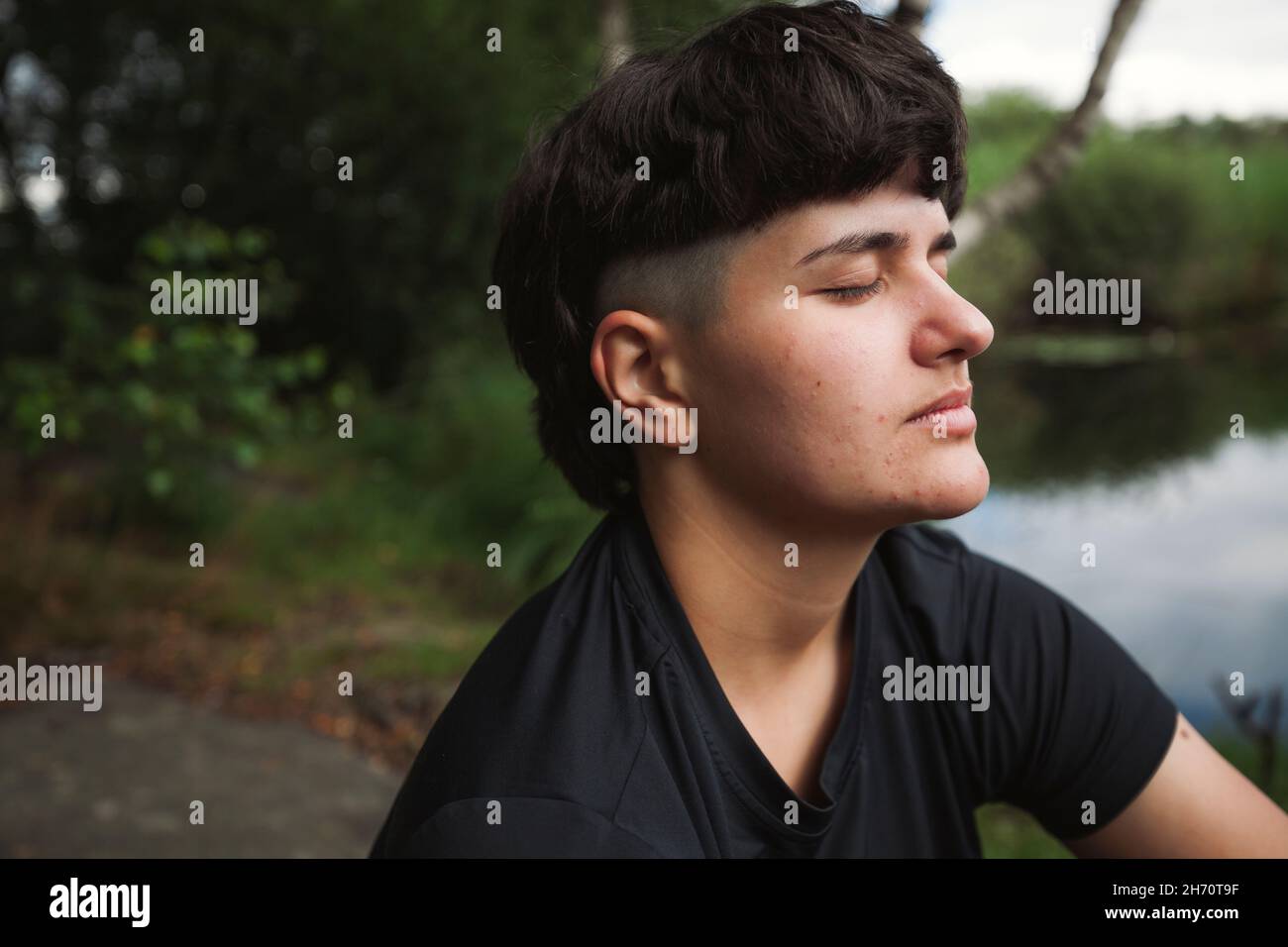Young woman relaxing at lakeside Stock Photo