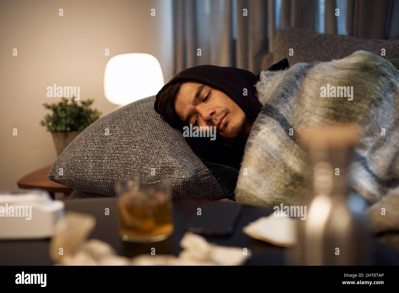 Ill young man sleeping on sofa Stock Photo