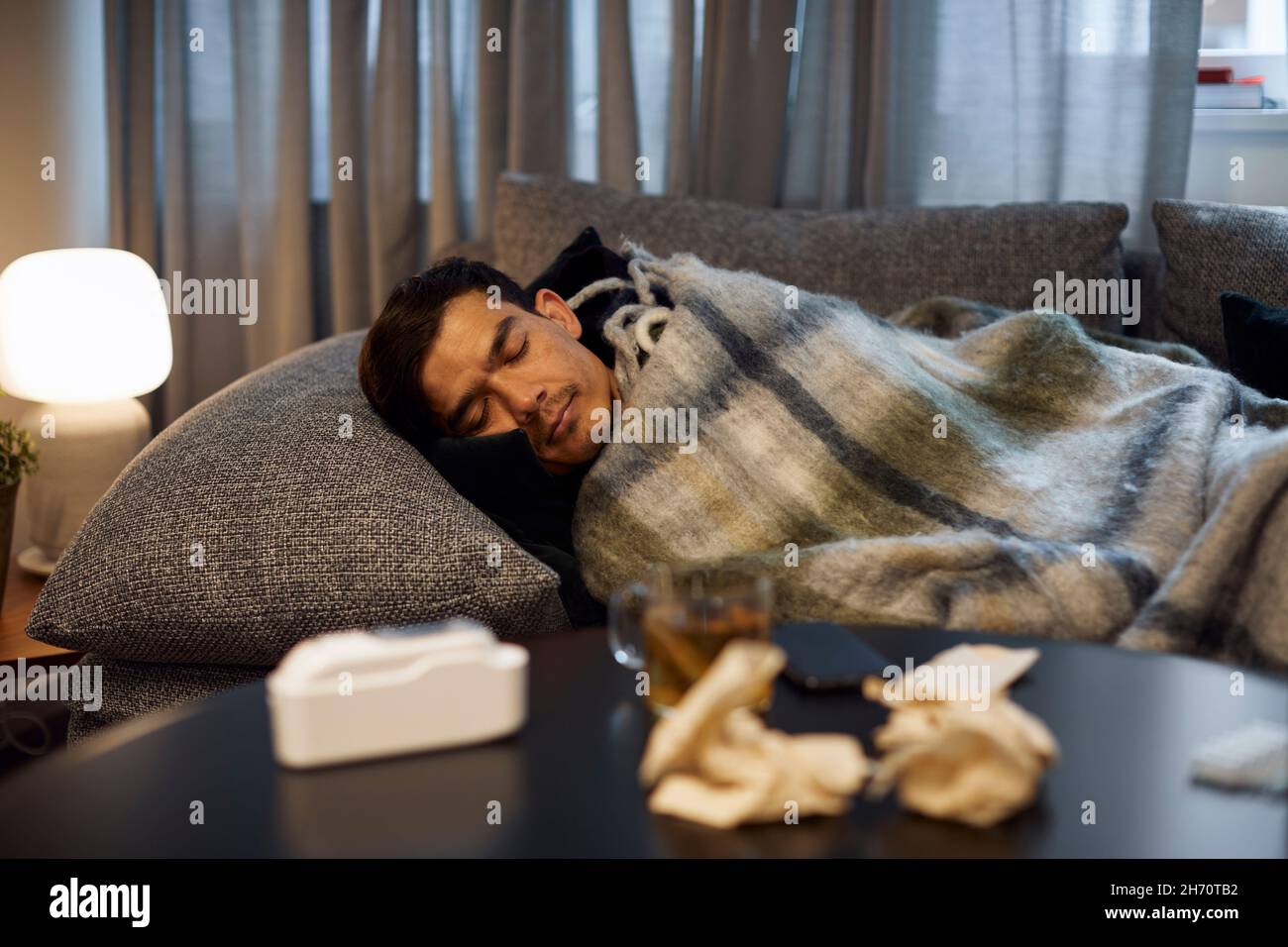 Ill young man sleeping on sofa Stock Photo