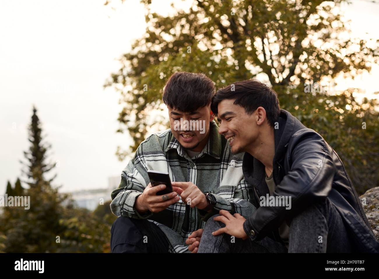 Young men using smart phone outdoors Stock Photo