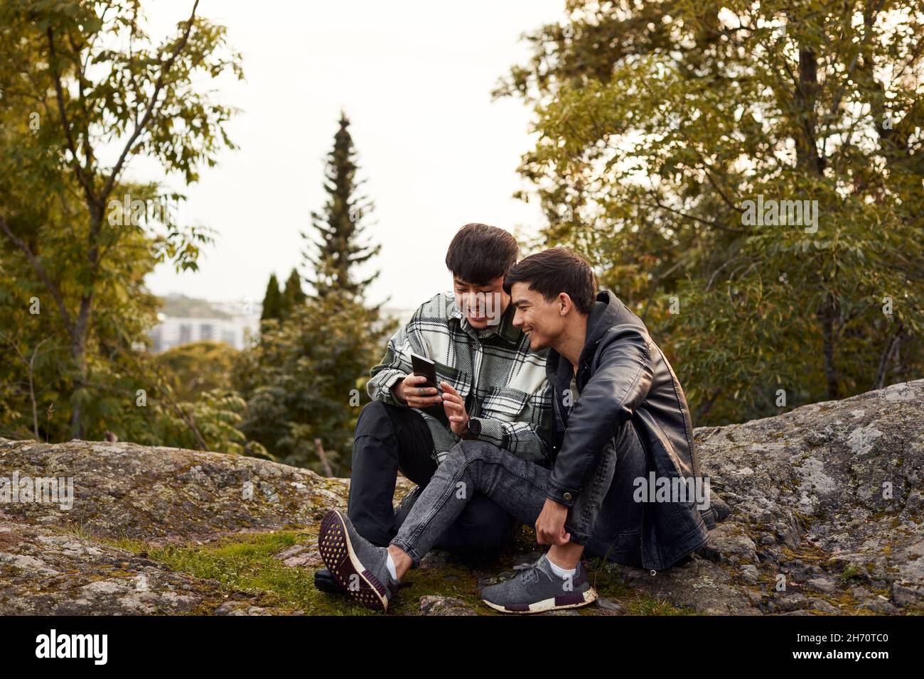 Young men using smart phone outdoors Stock Photo