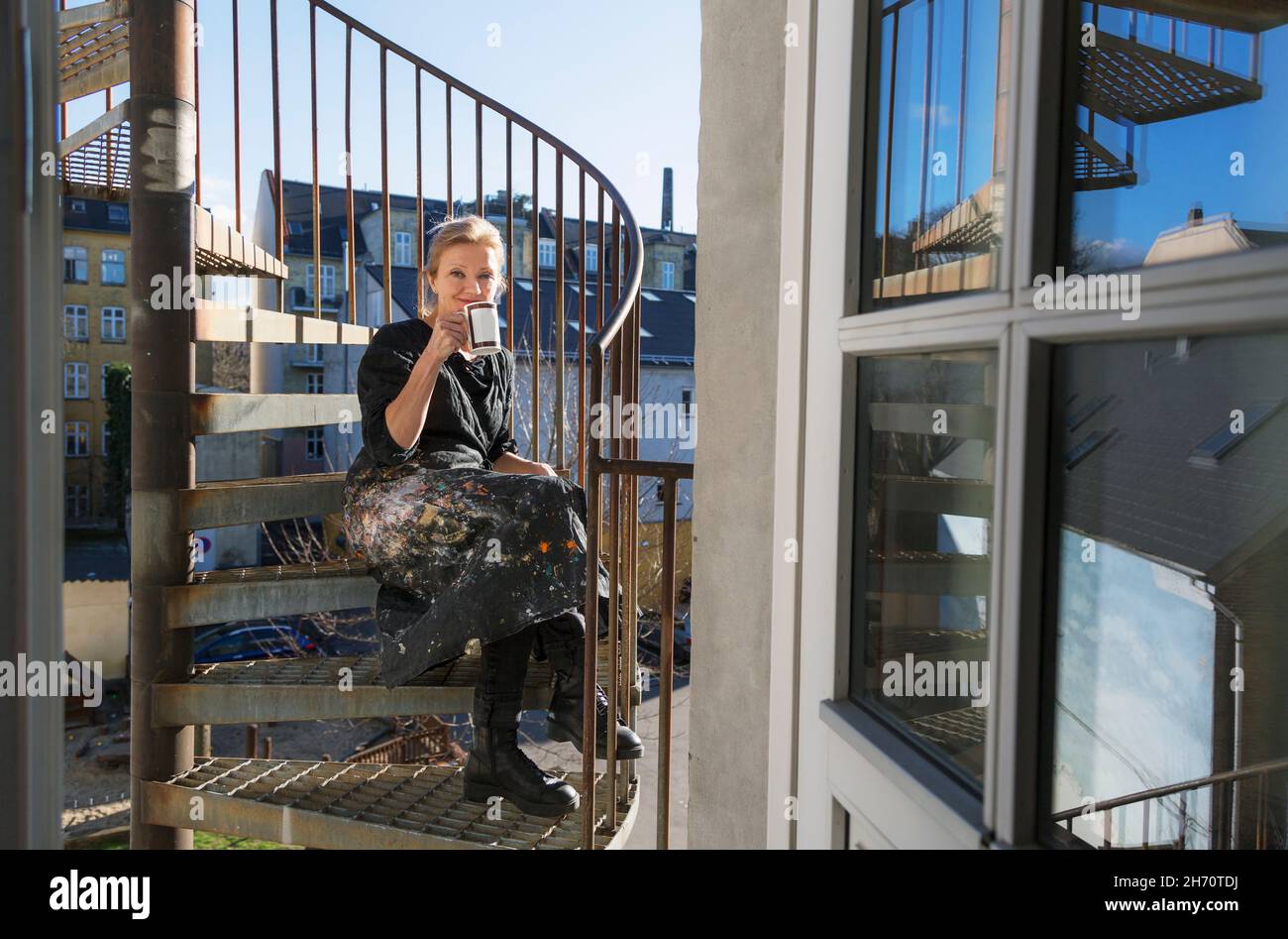 Woman sitting on fire stairs Stock Photo
