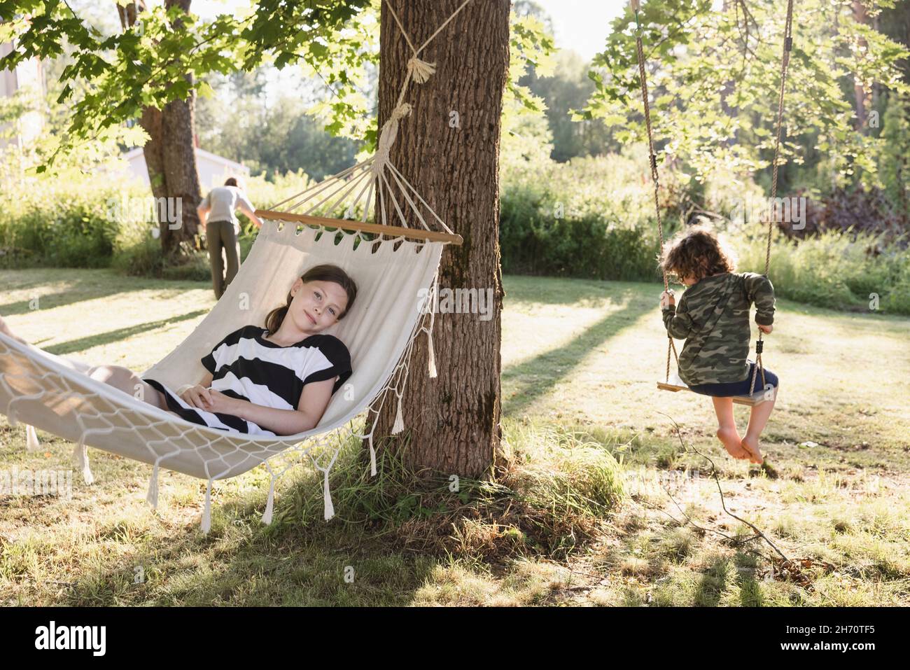 Girl and boy on hammock and swing Stock Photo