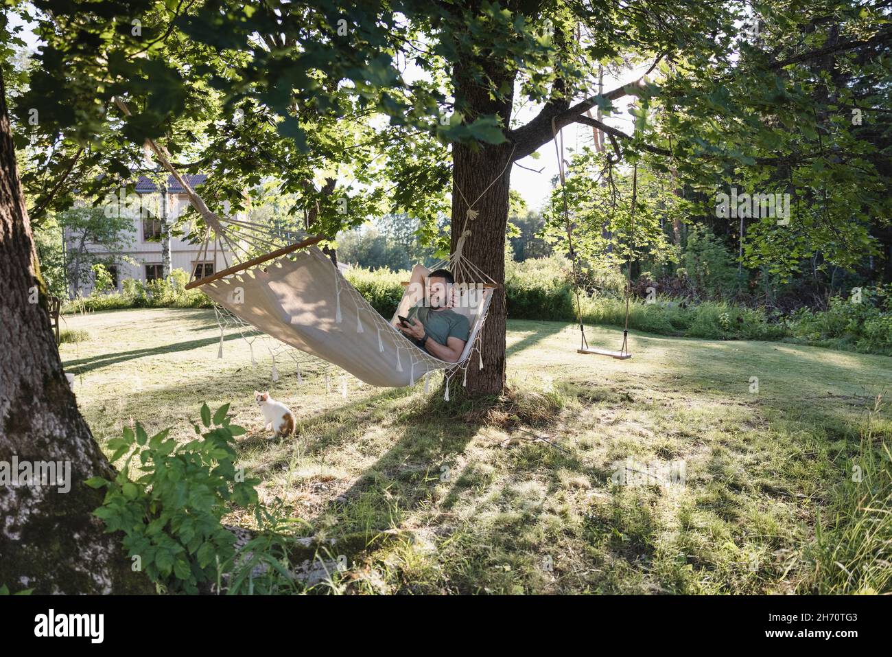 Mid adult man lying in hammock hi-res stock photography and images - Alamy