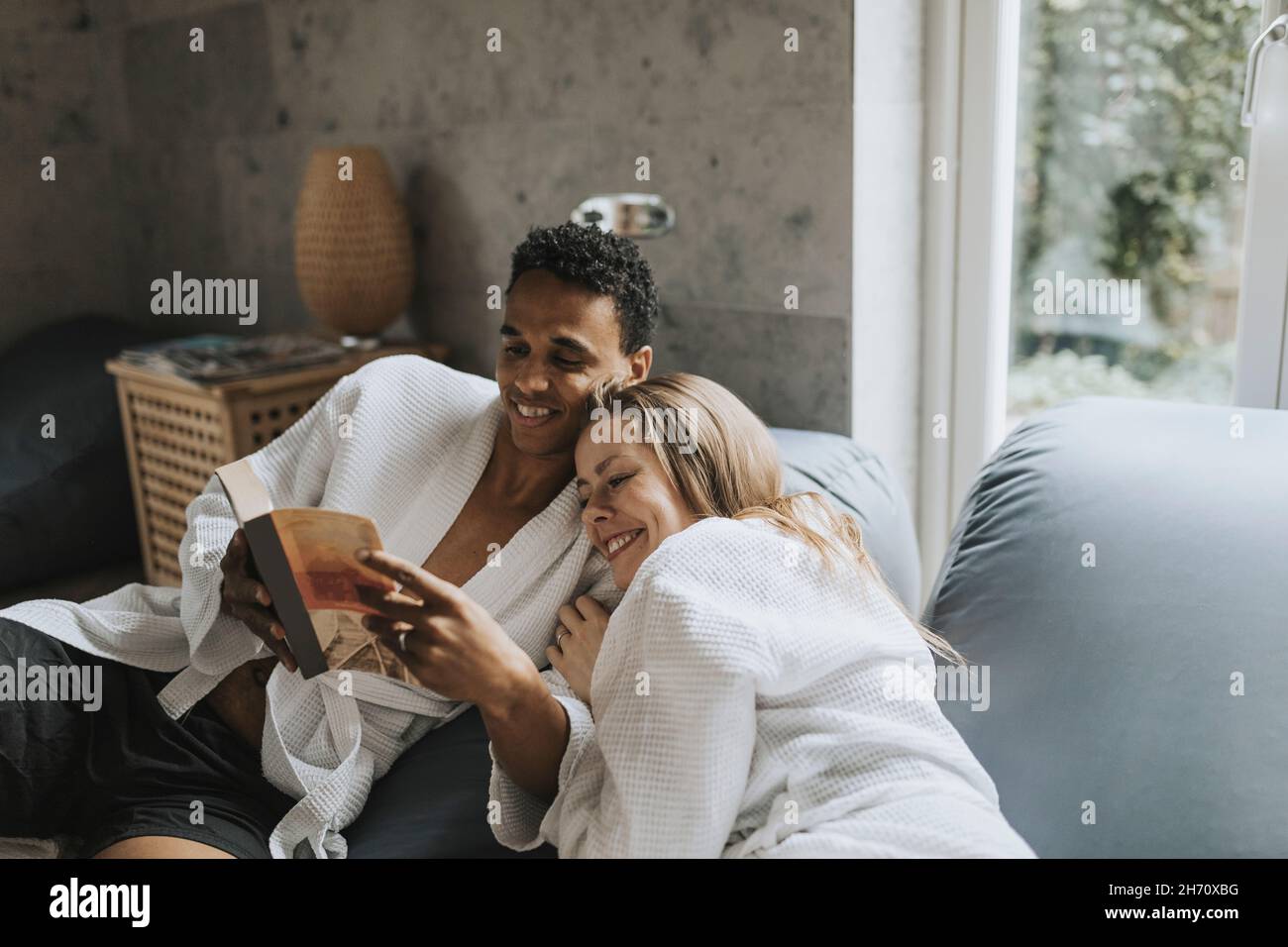 Smiling couple sitting together on sofa Stock Photo