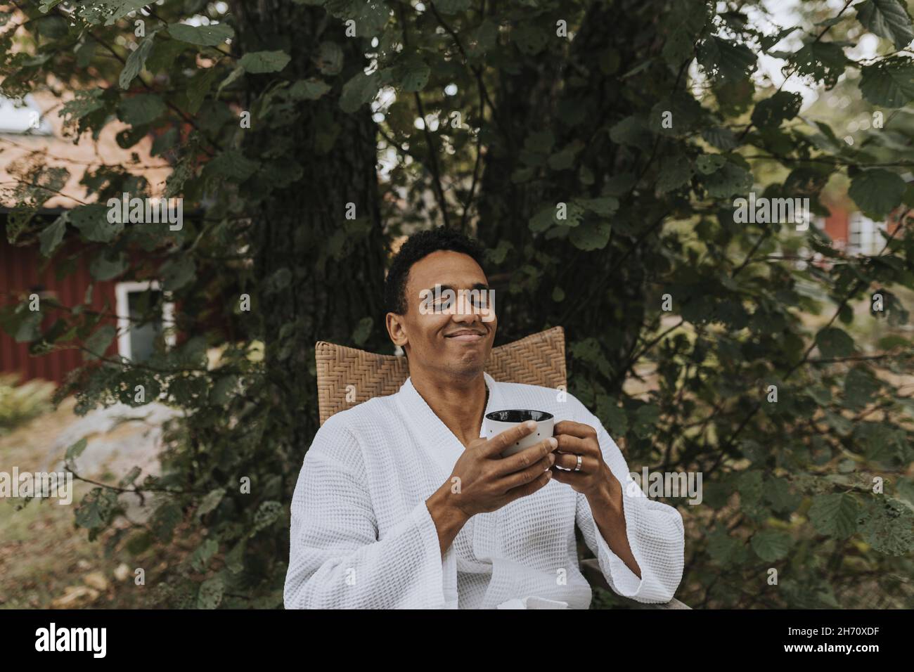Smiling man having coffee in garden Stock Photo