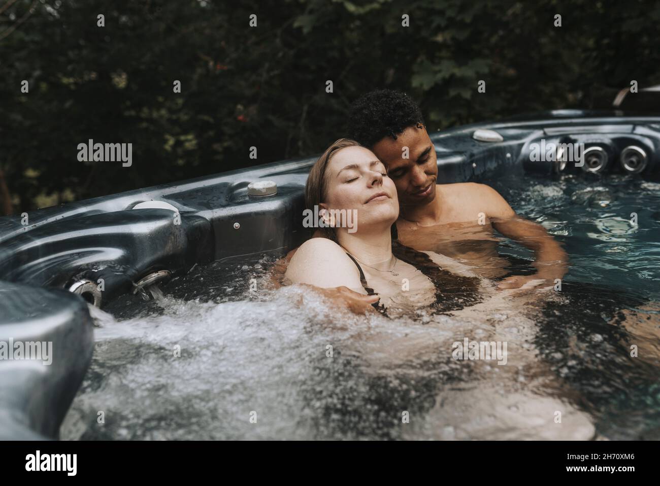 Couple relaxing in hot tub Stock Photo