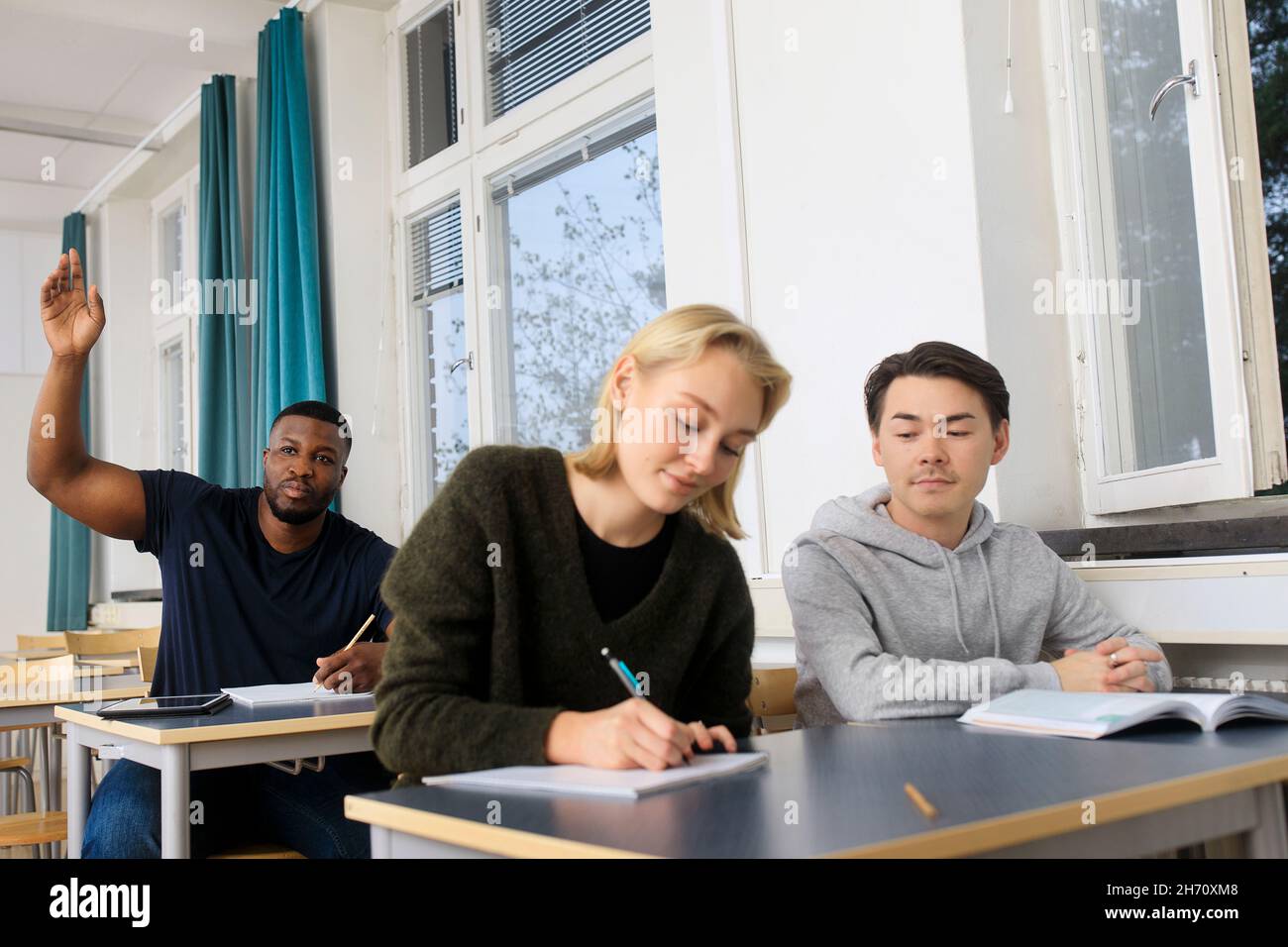 Smiling students in classroom Stock Photo