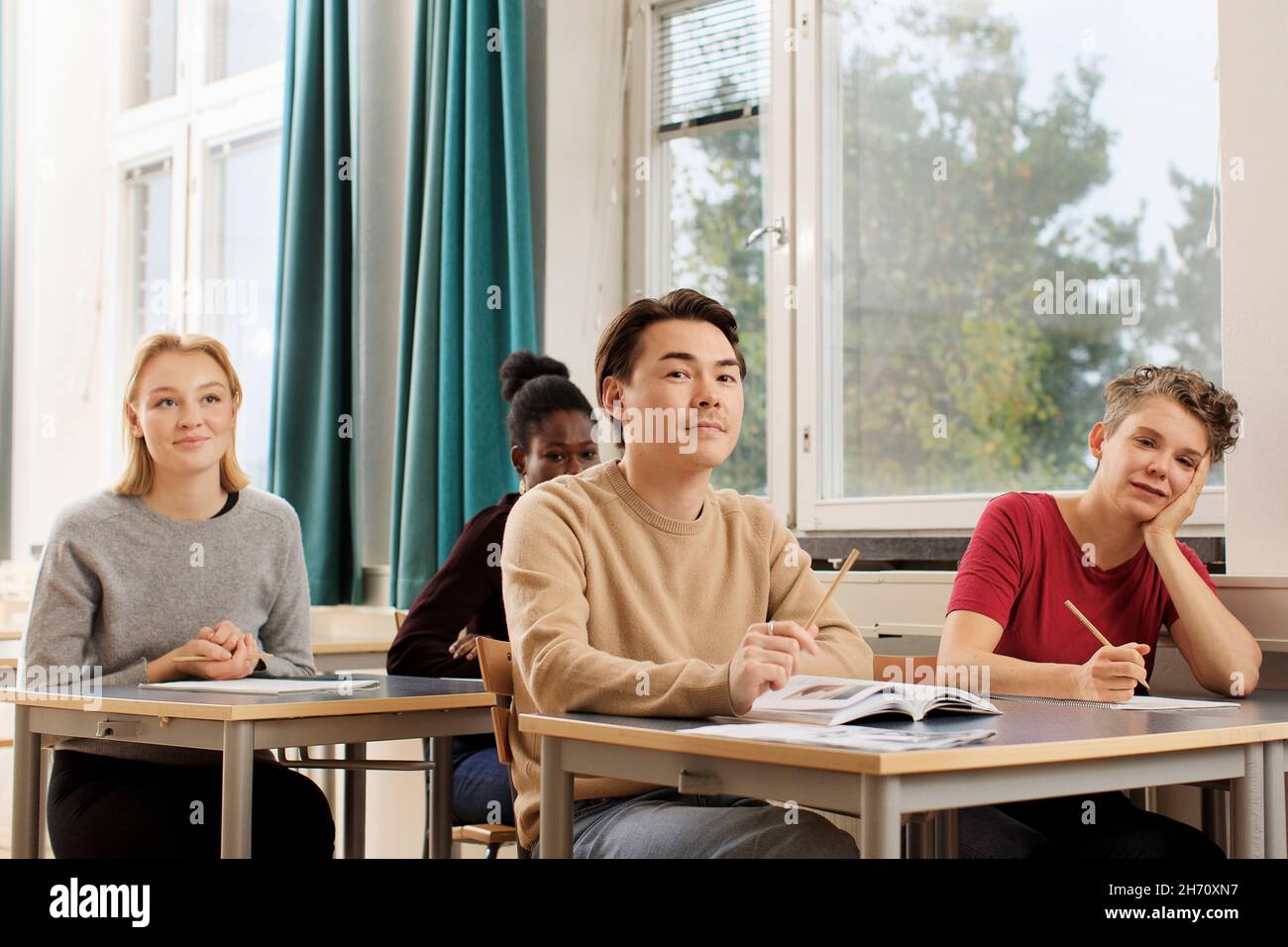 Smiling students in classroom Stock Photo