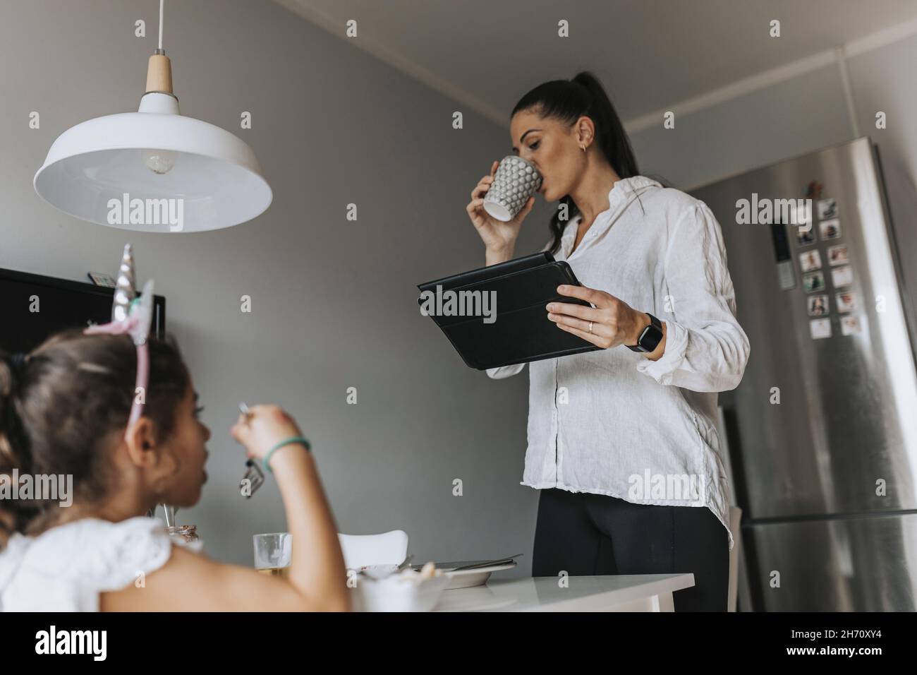 Woman using digital tablet in kitchen Stock Photo